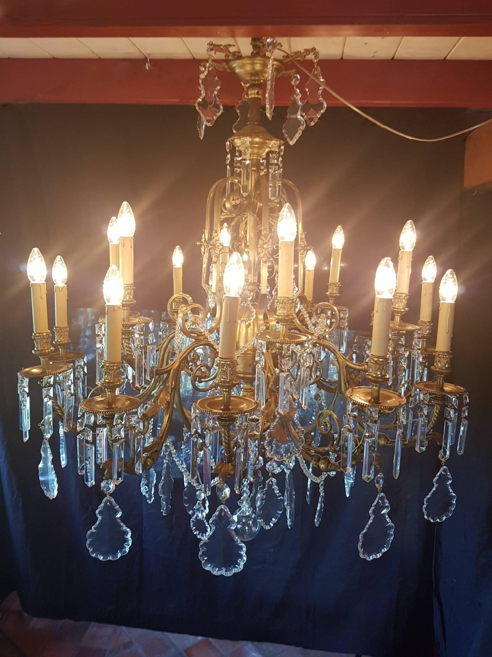 Large French brass chandelier converted from gas to electricity. This big model has 18 lights and is richly decorated with nice glass and crystal pendeloques.

This is just one of our large collection chandeliers. Besides the old and antique