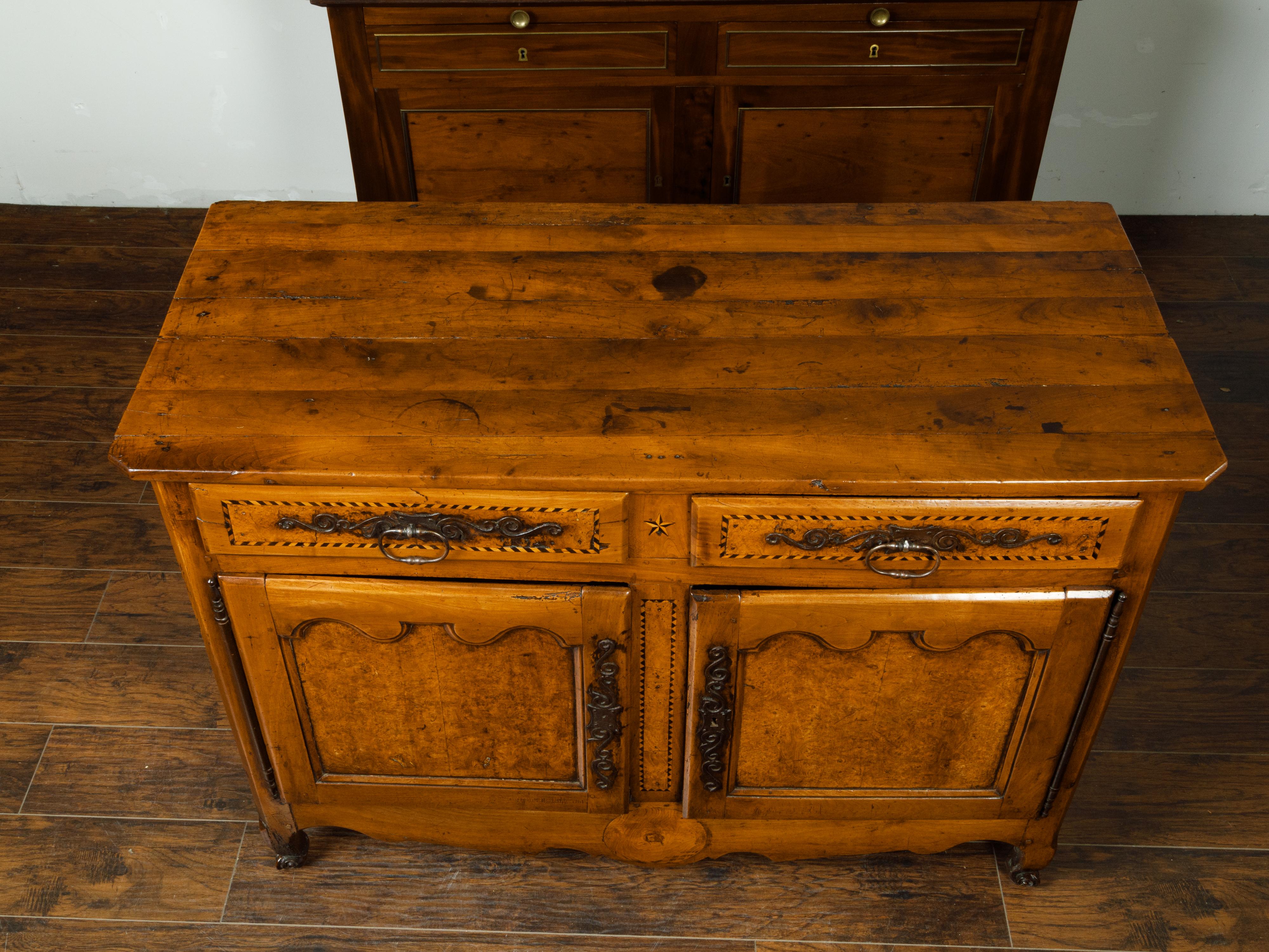 A French buffet from the early 19th century, with two drawers, two doors and burl accents. Created in France during the early years of the 19th century, this buffet features a rectangular planked top with canted corners in the front, sitting above