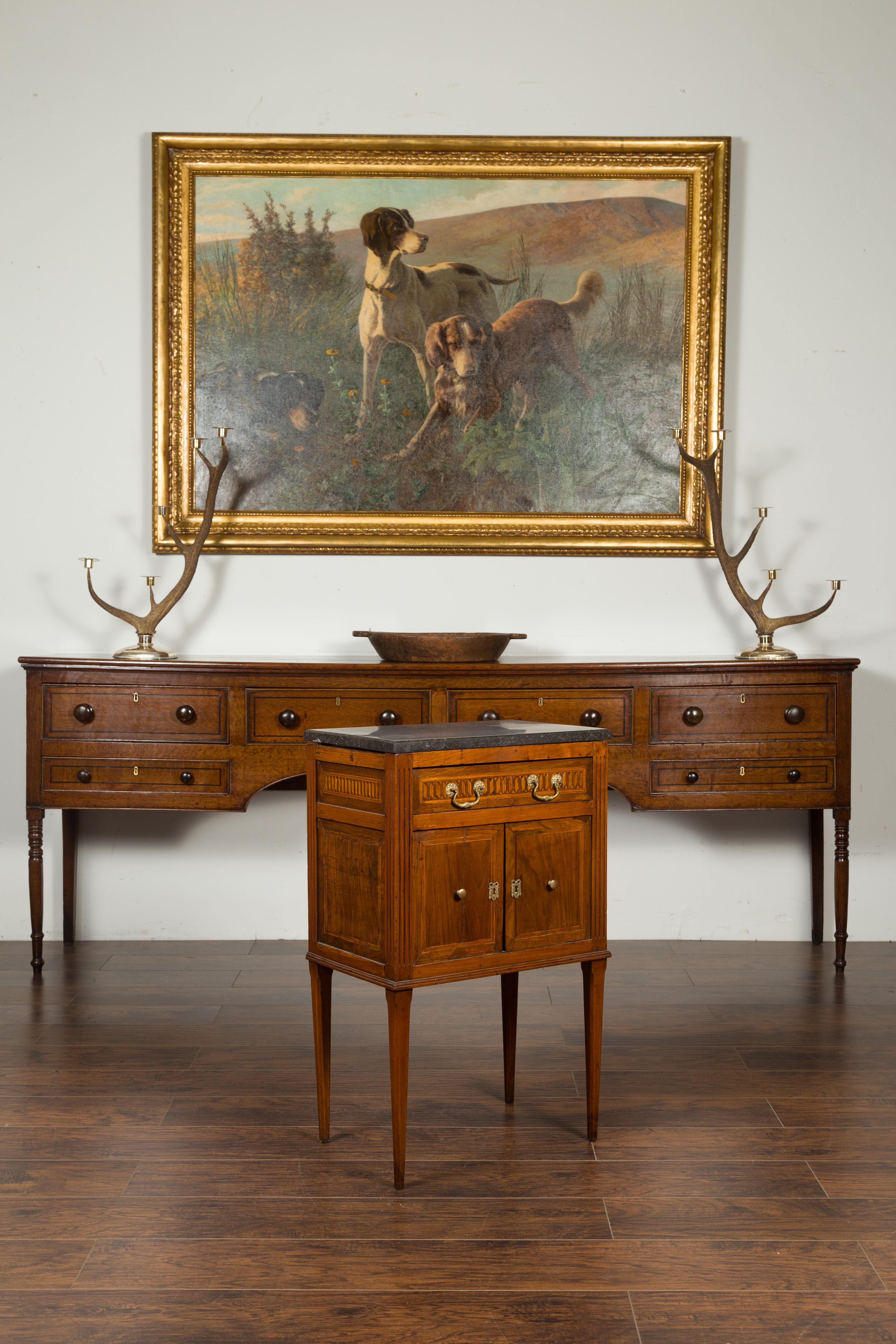 A French neoclassical period walnut side table from the early 19th century, with marquetry decor and dark grey marble top. Created in France during the early years of the 19th century, this walnut side table features a dark grey marble top sitting