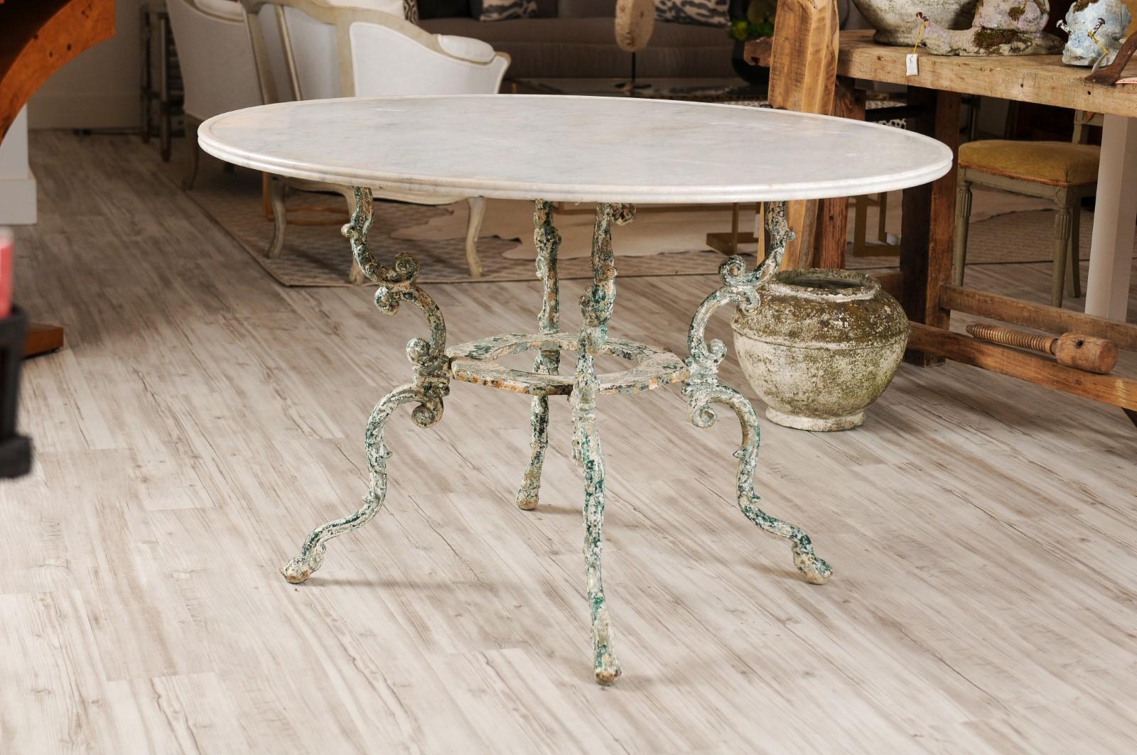 A French patinated wrought iron table from the early 19th century, with round marble top sitting above four scrolled legs. From one of our favourite and most trustworthy vendors in France, we bought this exquisite early 19th century table, with a