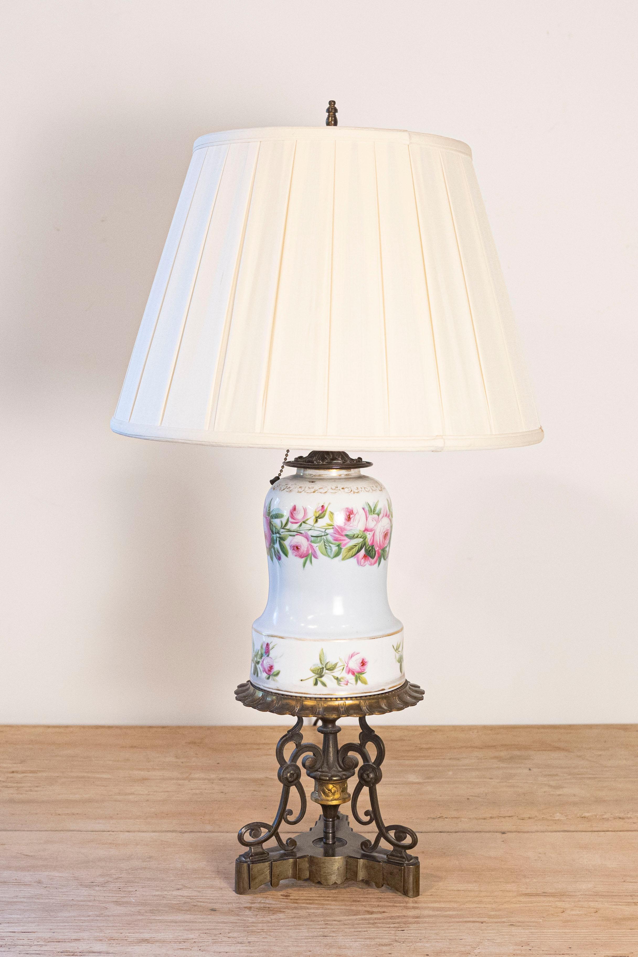 A French table lamp made from an original early 19th century porcelain oil lamp. Created in France during the first quarter of the 19th century, this porcelain oil lamp has been transformed into a table lamp wired for the US. Adorned with delicate