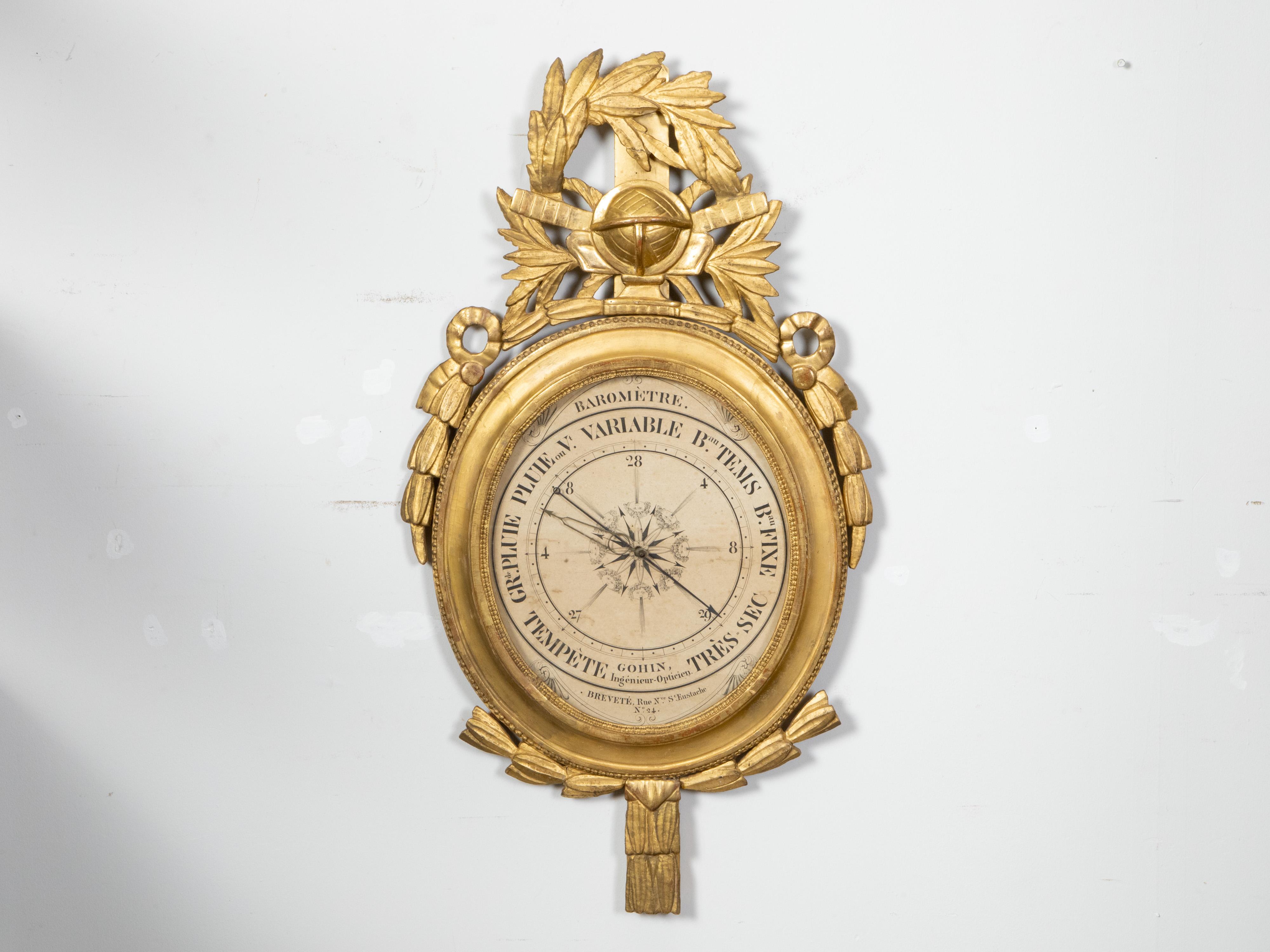 Baromètre en bois doré sculpté d'époque Restauration, datant du début du 19e siècle, signé Gohin Ingénieur-Opticien sur la face. Créé en France à l'époque de la Restauration, ce baromètre en bois doré retient l'attention par son écusson sculpté