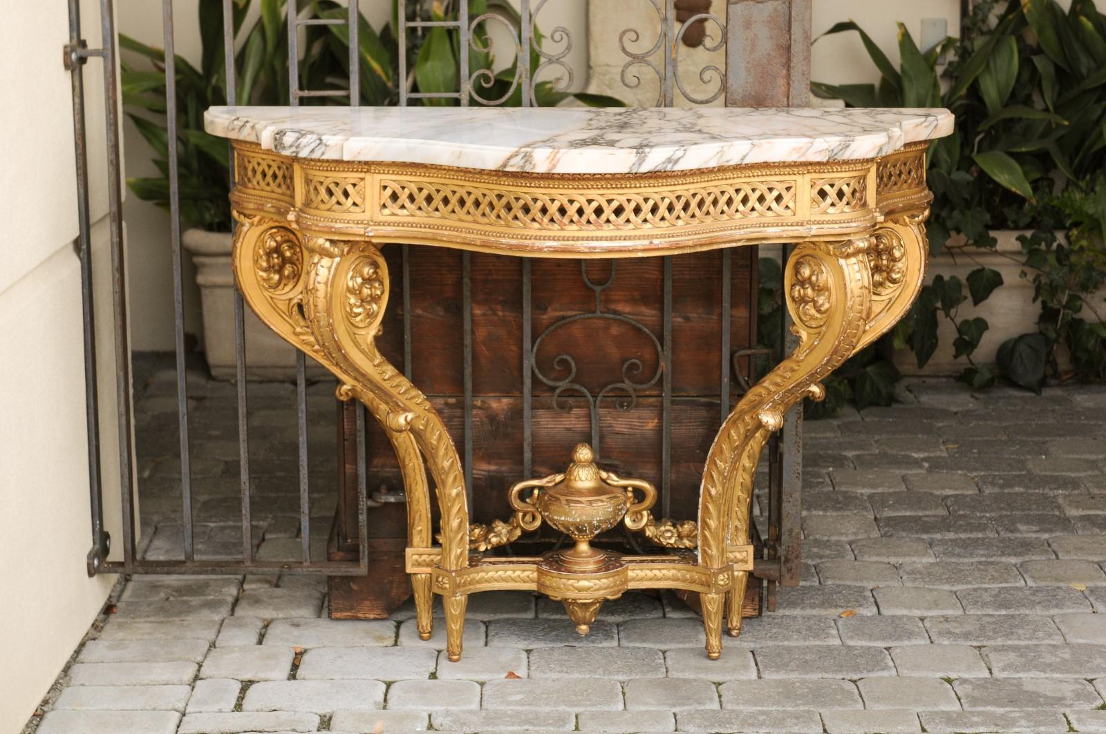 A French restauration period carved giltwood console table from the early 19th century, with serpentine marble top and scrolled swan neck legs. Born in France during the early years of the 19th century that saw the brief return of monarchy after the