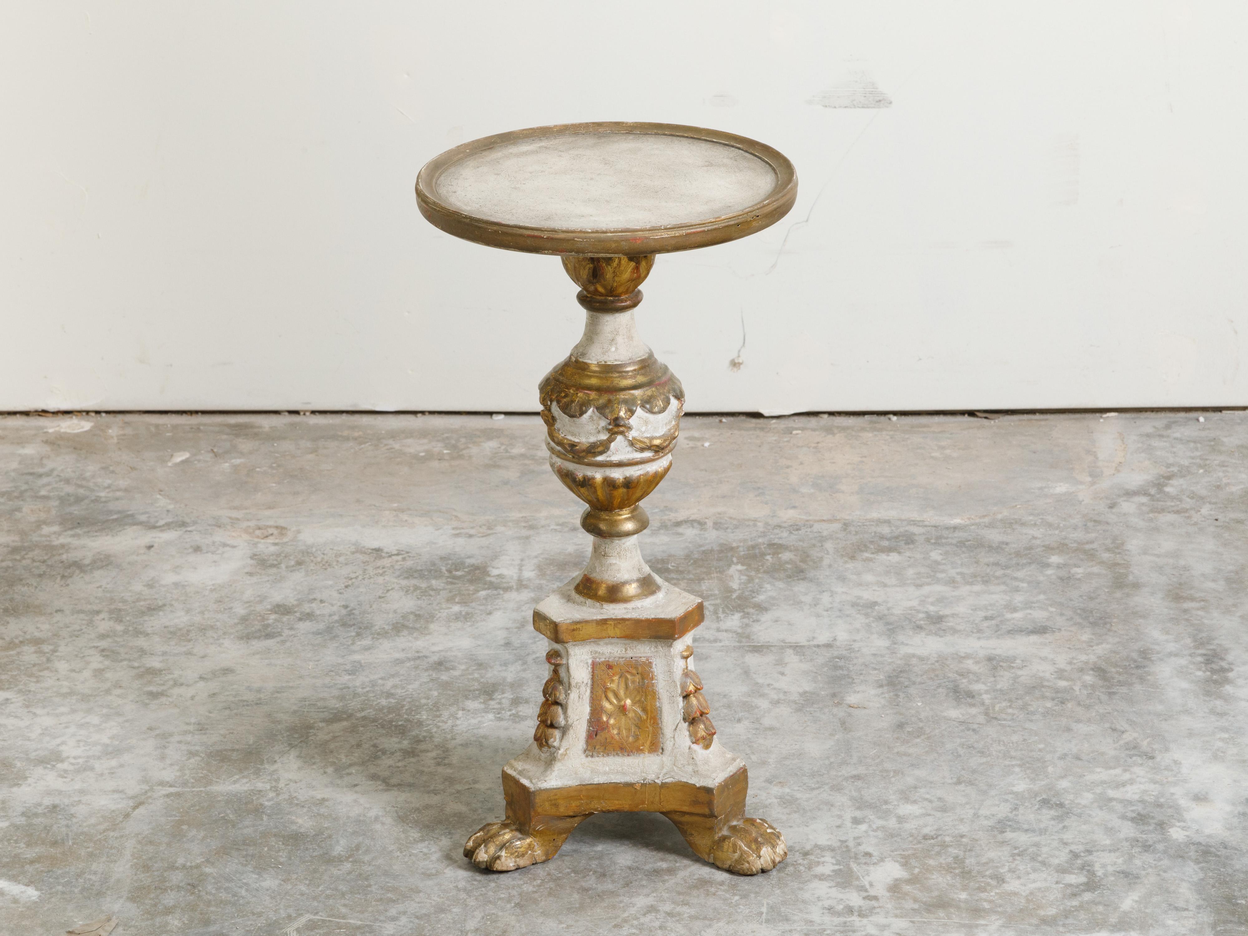 A French Restauration period painted and gilded guéridon table from the early 19th century, with carved motifs and lion paw feet. Created in France during the reign of King Louis XVIII, this guéridon table features a circular top sitting above