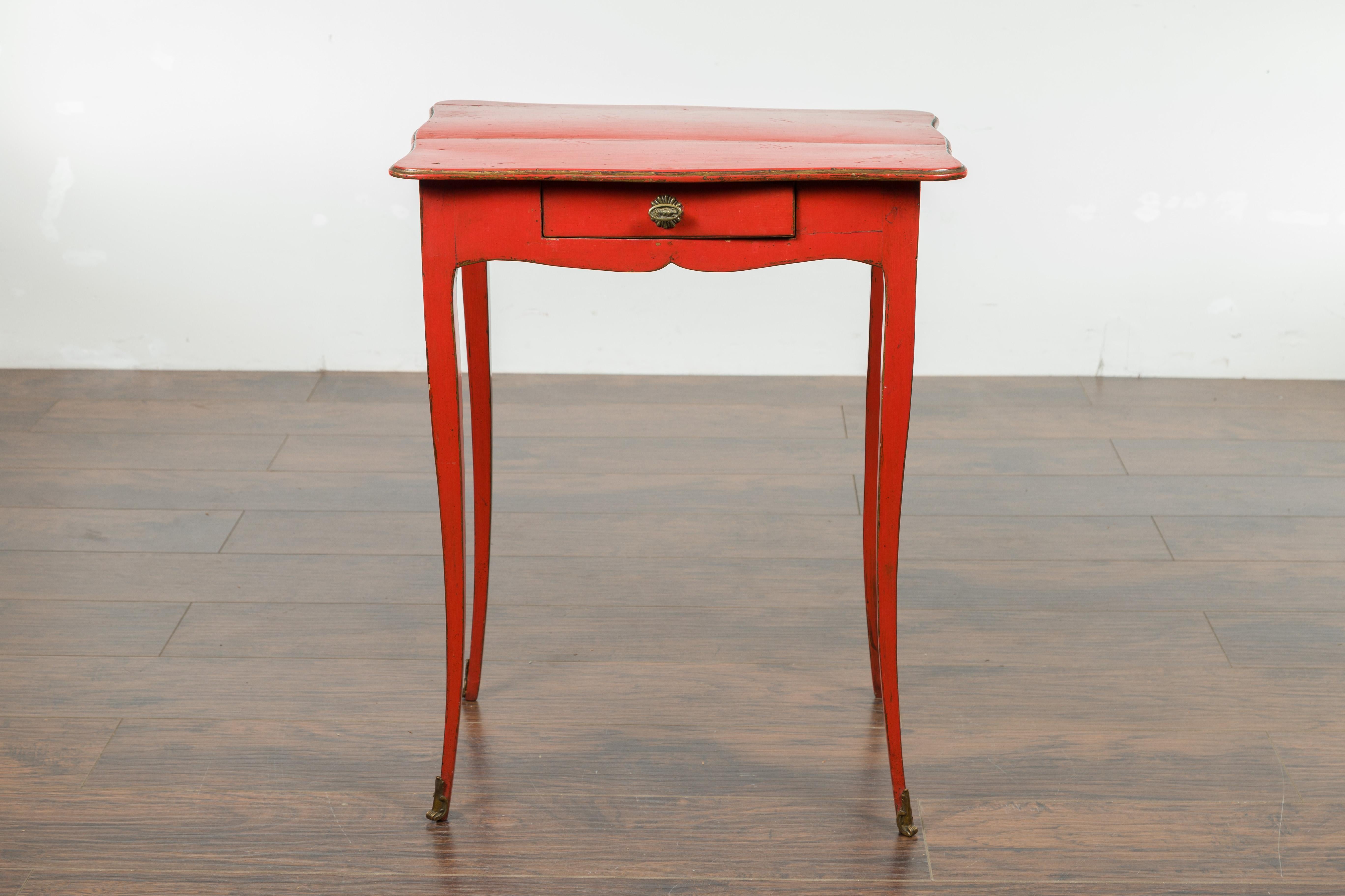 A French Restauration period red side table from the early 19th century, with curving legs and single drawer. Created in France during the first quarter of the 19th century, this red side table features a rectangular top with serpentine lines,