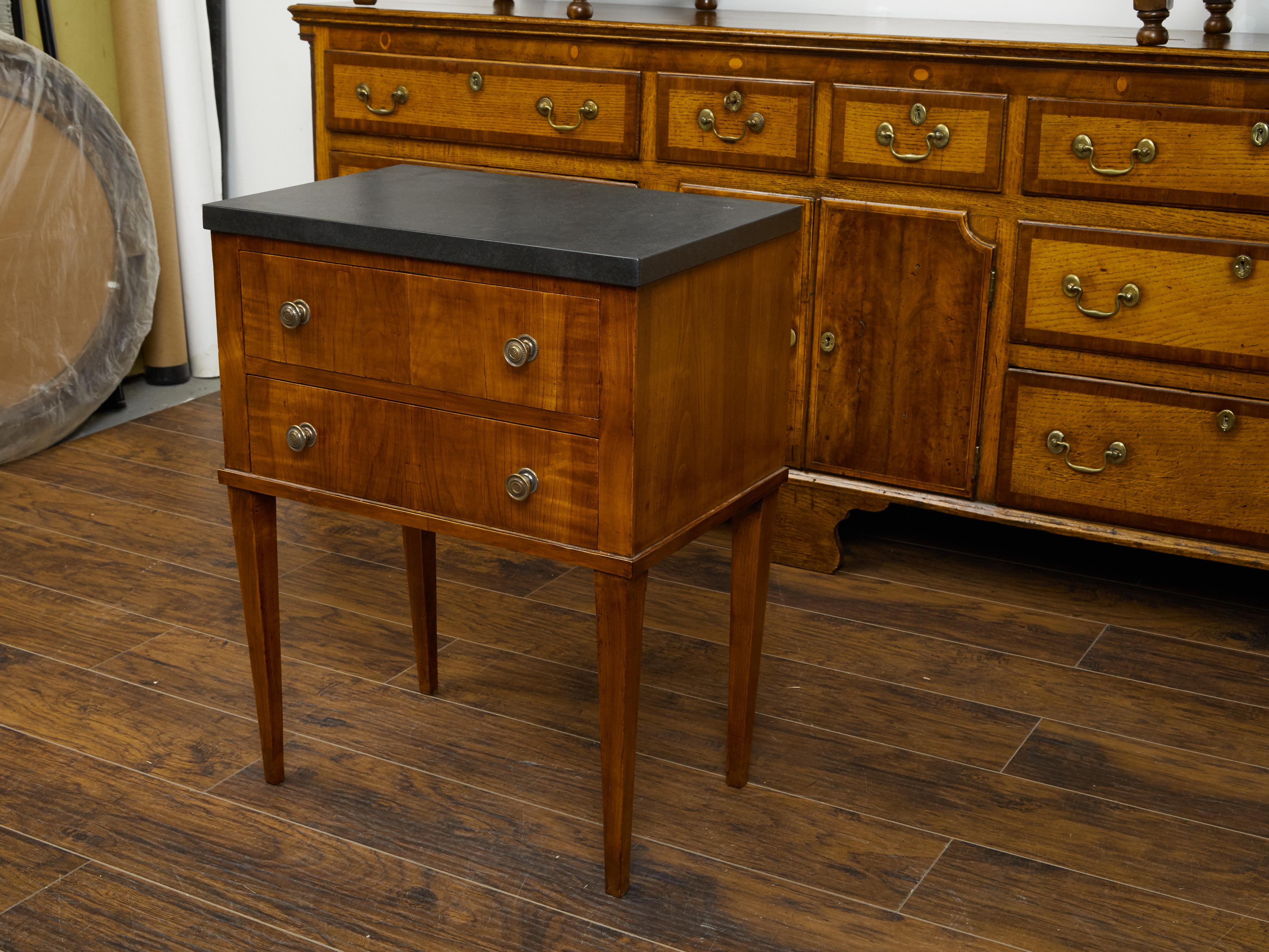A French Restauration period walnut 'table de chevet' from the early 19th century, with marble top and two drawers. Created in France during the first quarter of the 19th century, this walnut table features a rectangular black marble top sitting