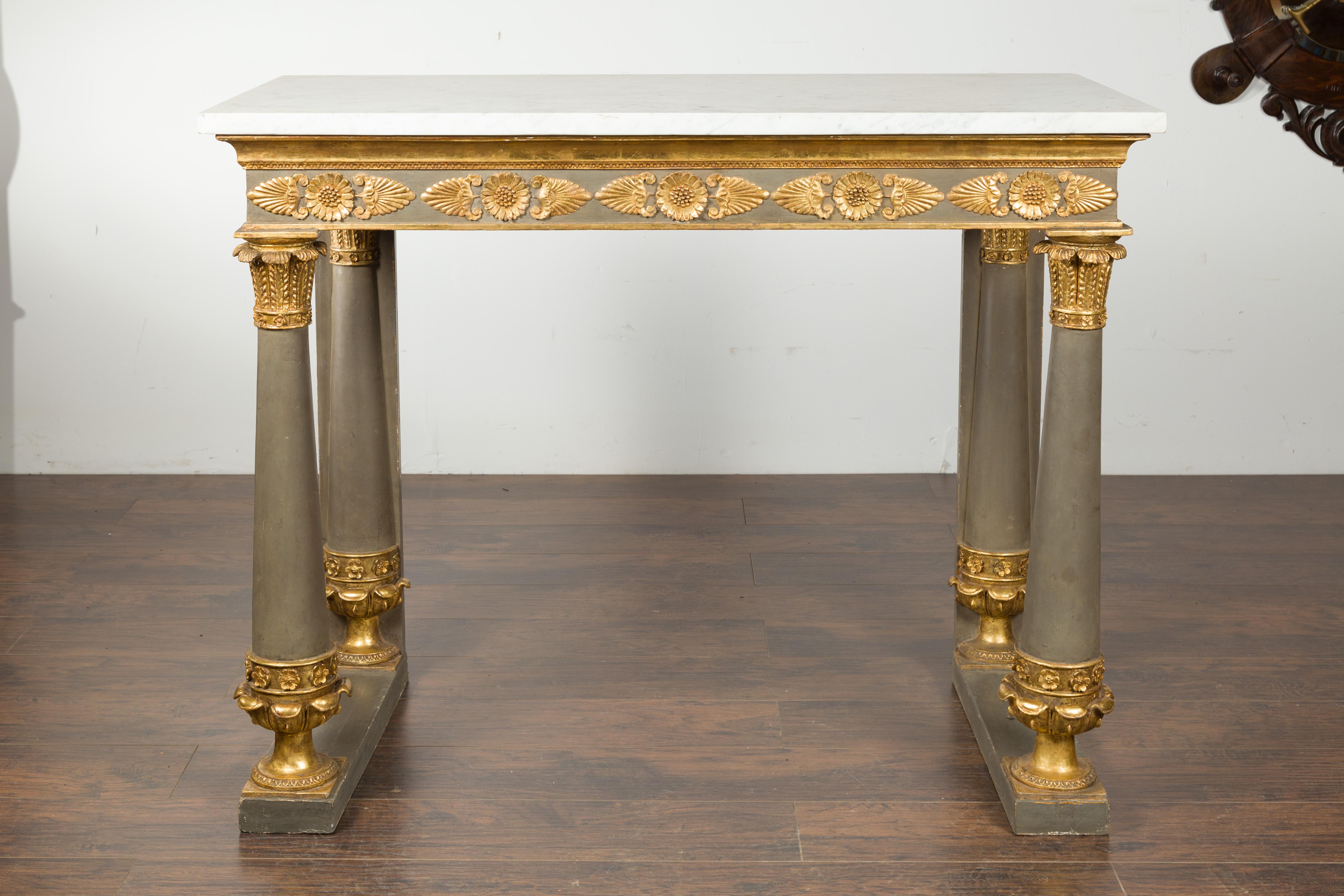A French Empire console table from the early 19th century, with white marble top and giltwood accents. Created in France during the second quarter of the 19th century, this Empire console table features a rectangular white marble top sitting above a