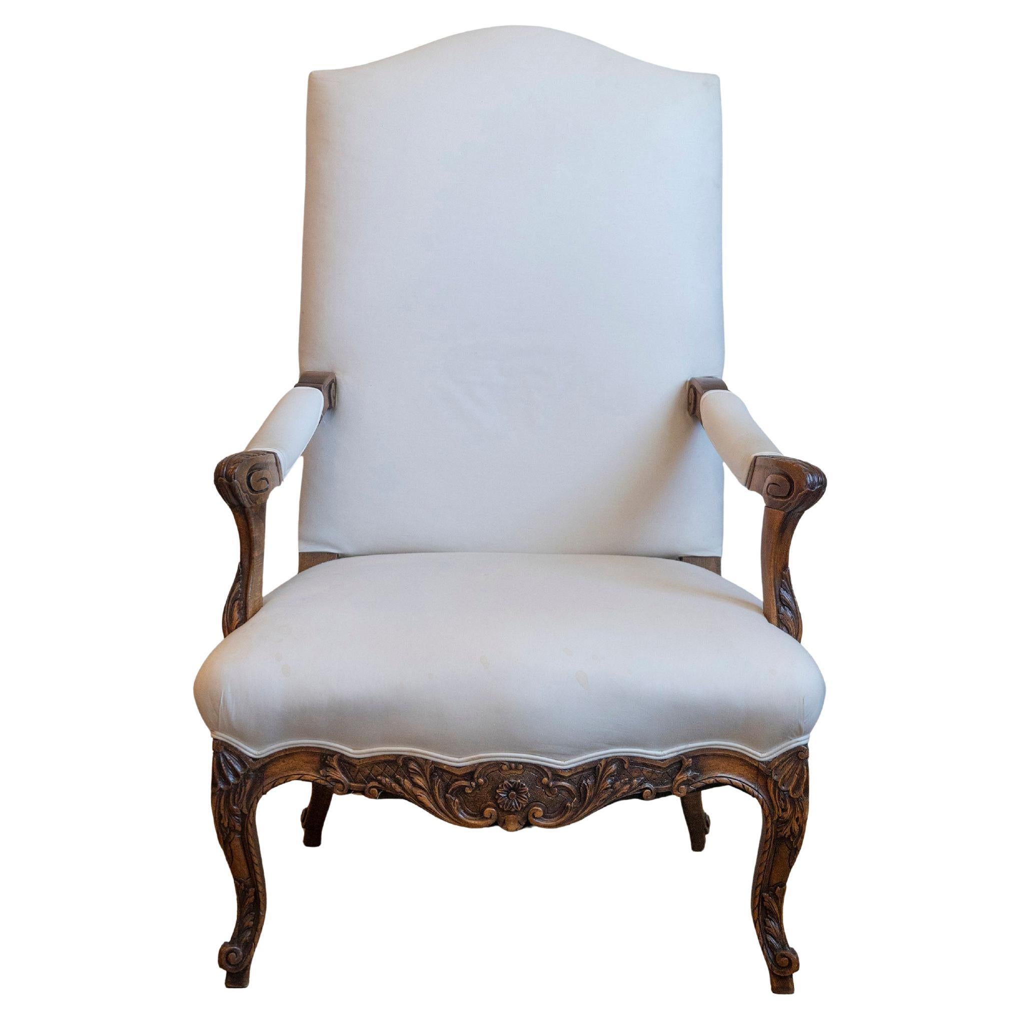 Un fauteuil francese in noce in stile Luigi XV della metà del XIX secolo, con accenti delicatamente intagliati e tappezzeria recente, emana un fascino e una raffinatezza senza tempo. Creata in Francia durante il secondo quarto del XIX secolo, questa