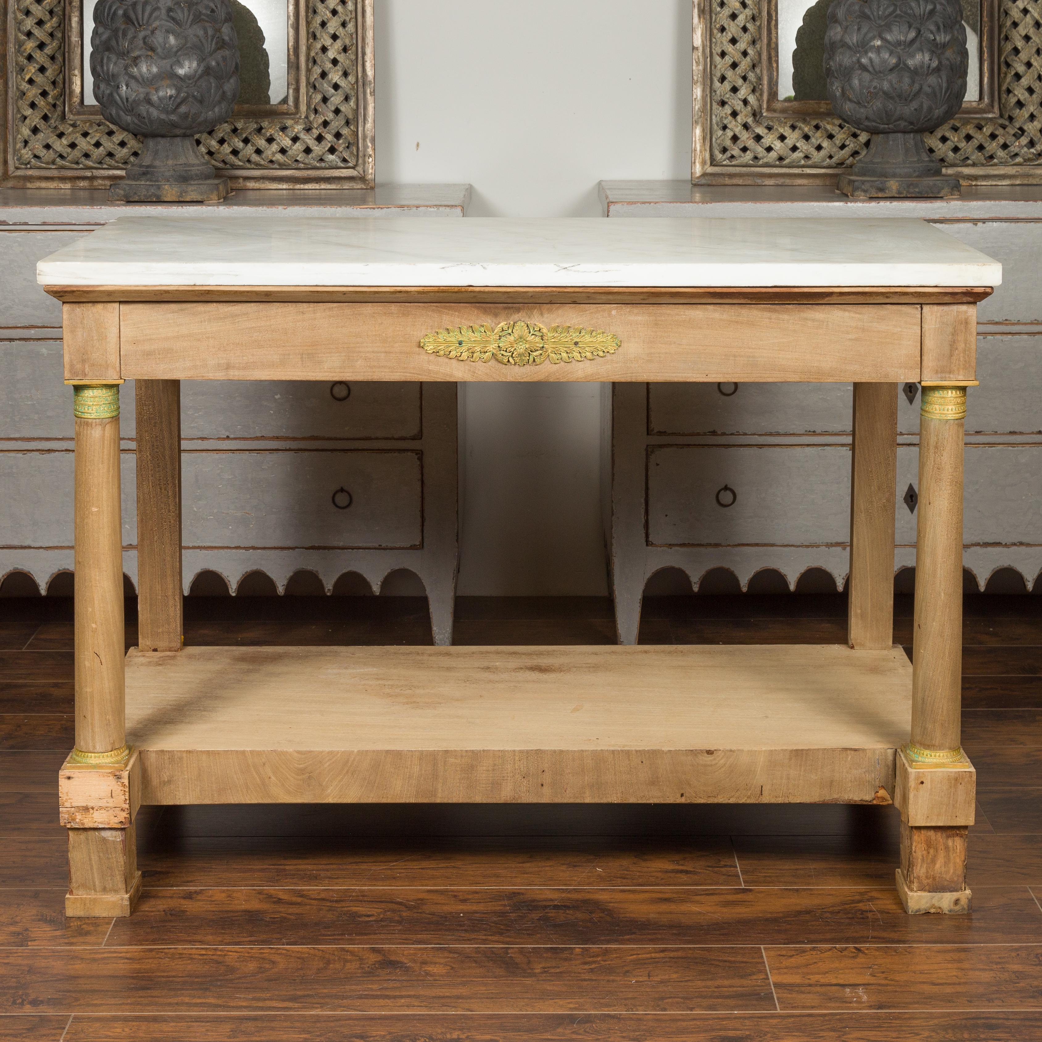 A French Empire style bleached wood console table from the mid-19th century, with white marble top and bronze accents. Born in France during the reign of Emperor Napoleon III, this console table presents the stylistic characteristics of the First