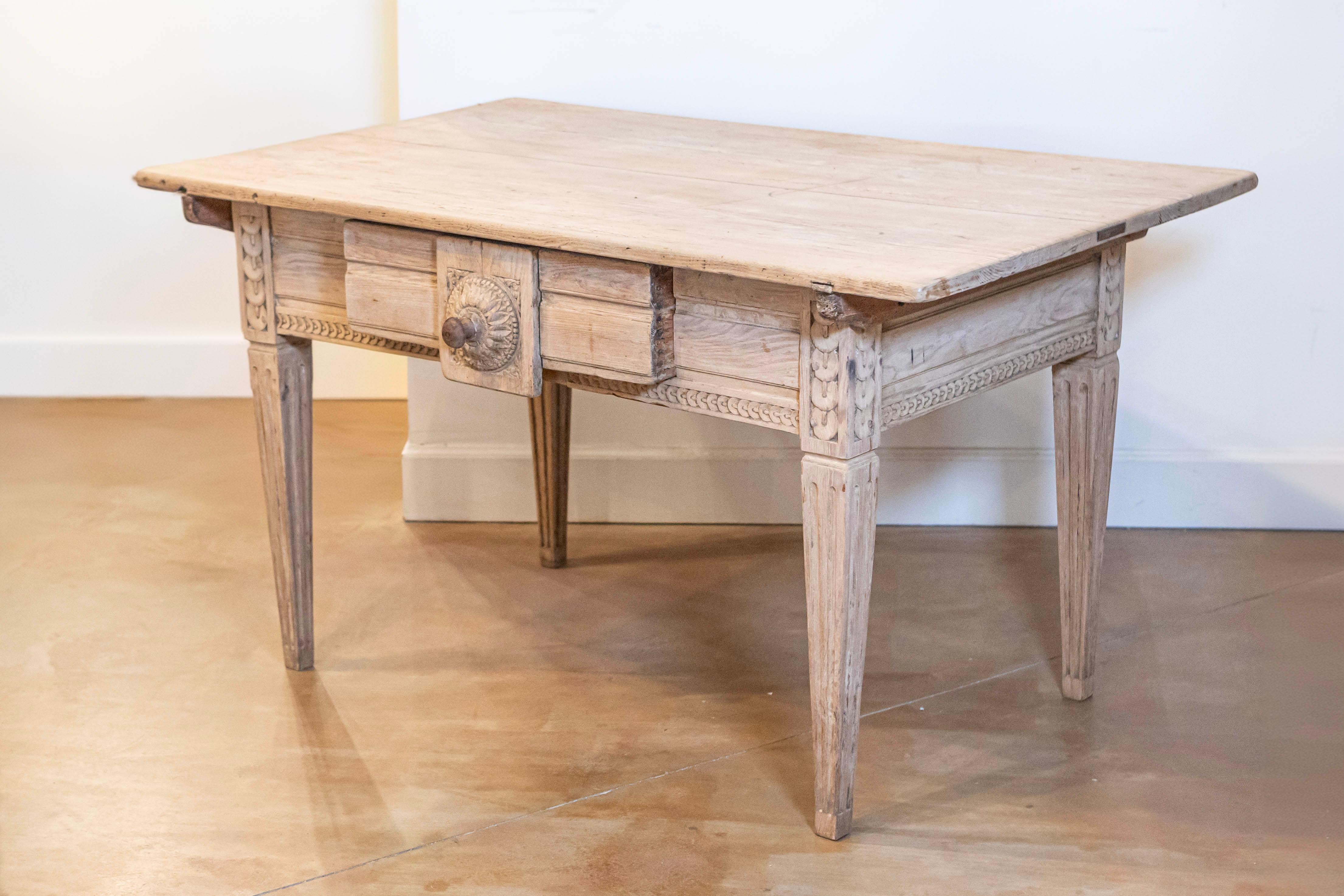 A French Napoléon III period Alsatian wooden center table from the mid 19th century, with carved stacked-coin style motifs, foliage and natural patina. Created in the Eastern region of Alsace during the reign of Emperor Napoléon III in the 1850s,