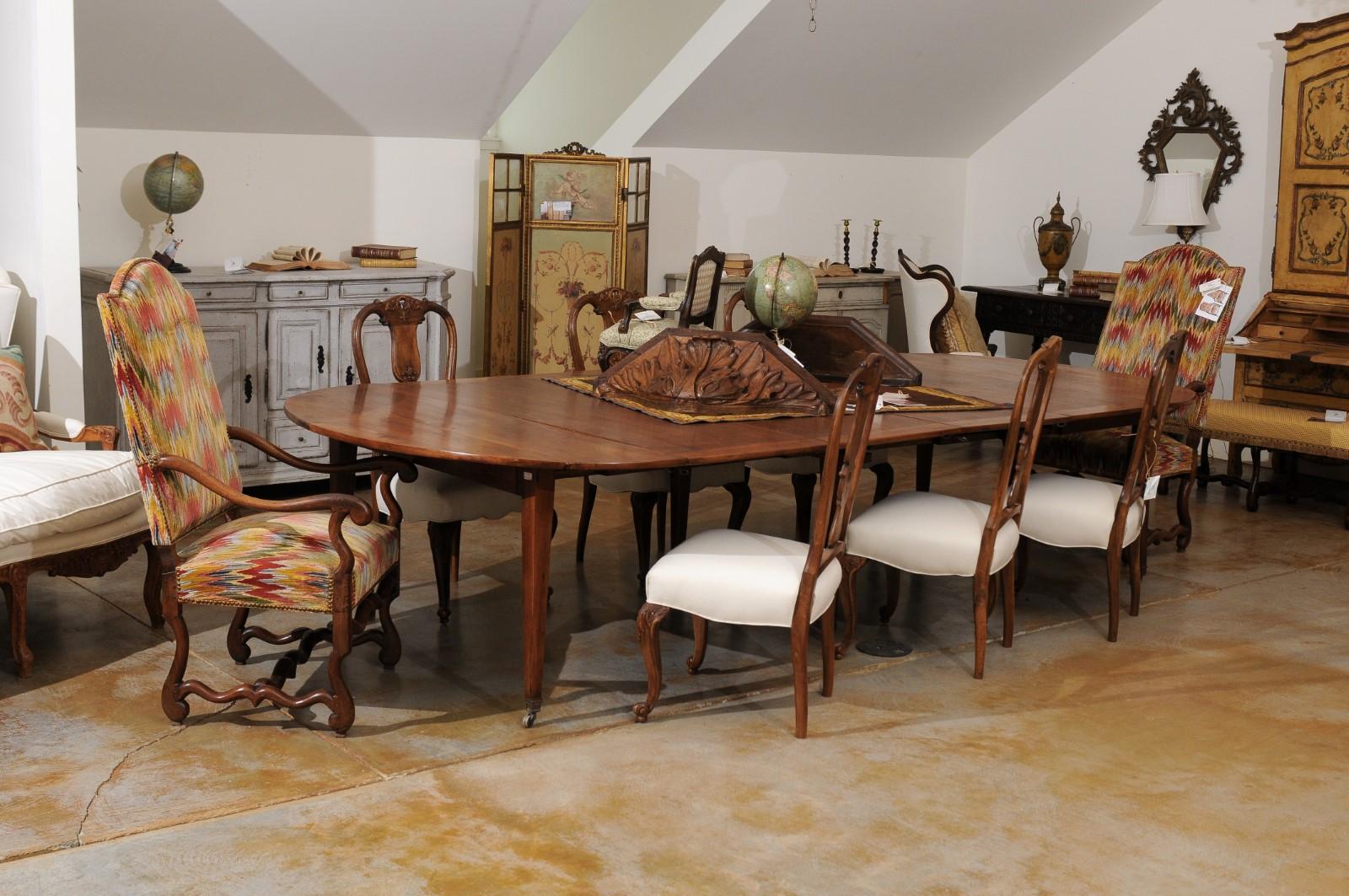A French Napoleon III period walnut oval extension dining room table from the mid-19th century, with drop leaves, four removable leaves, tapered legs and casters. Born in France during the 1850s, this French dining room table features a walnut oval