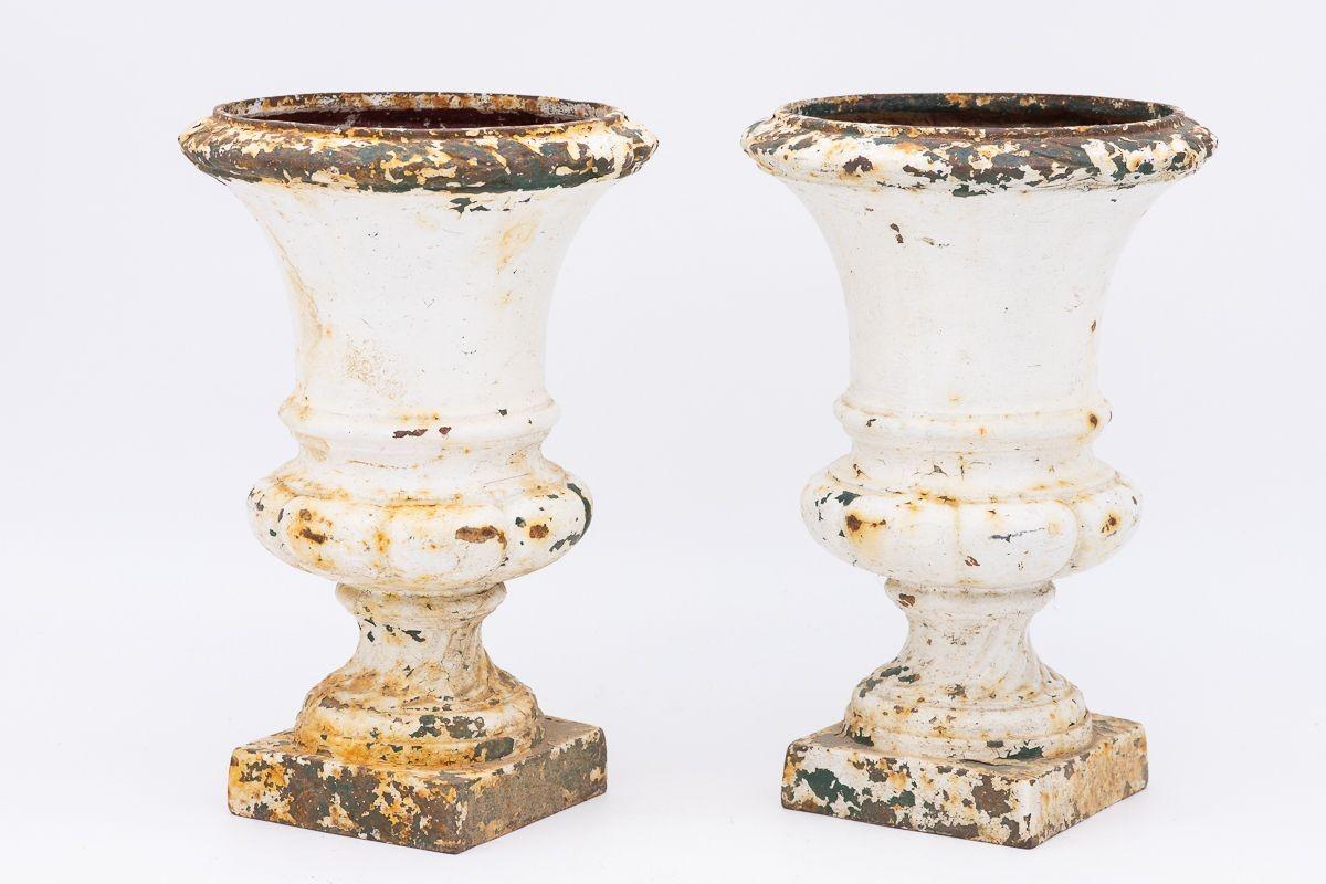 A pair of French 1860s white painted cast iron urns. Wear consistent with age and use.