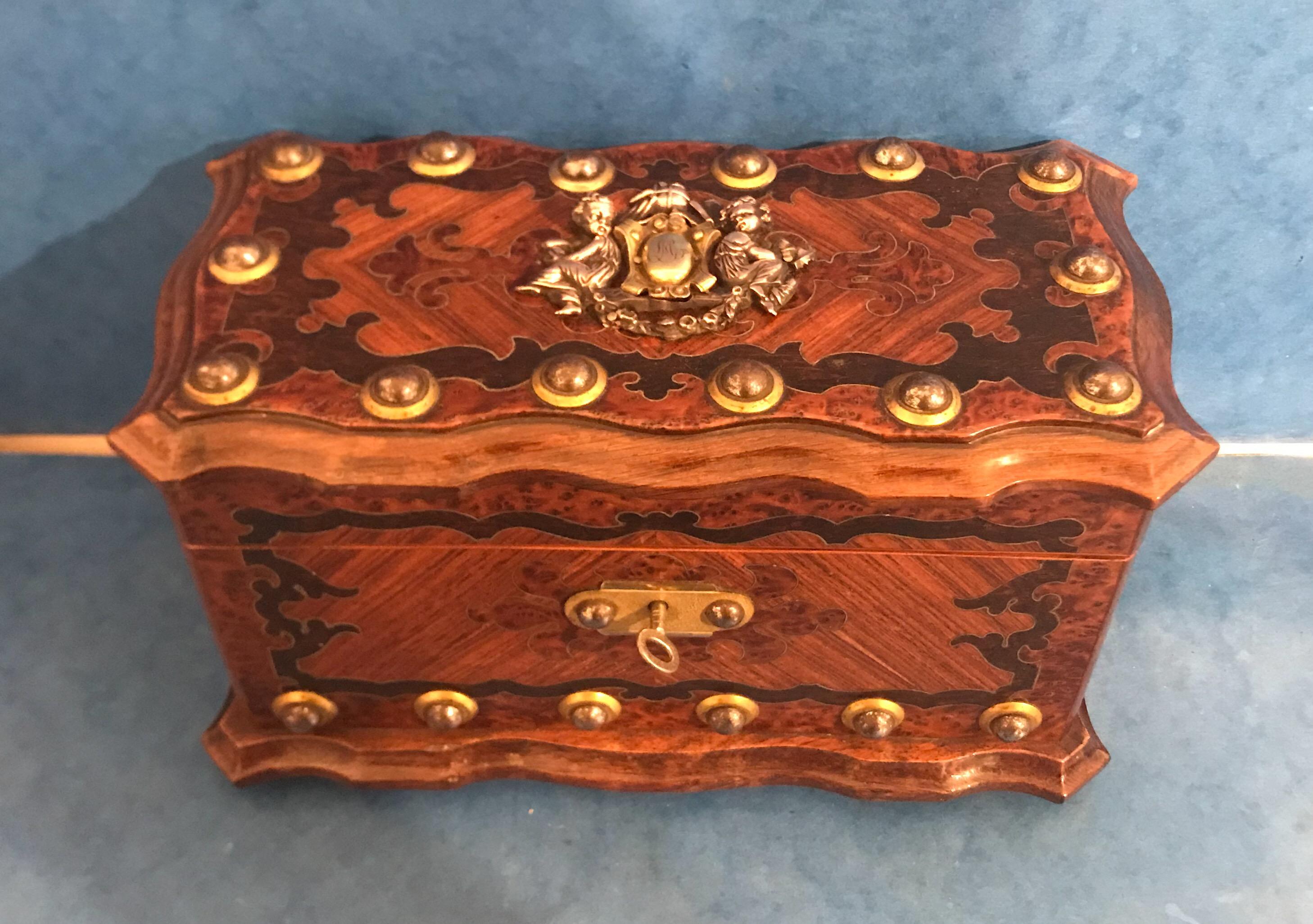 A beautiful French 1860 tea caddy. It is brass inlaid burr cedar, tulipwood and rosewood. It also has steel studs and brass-mounted. It is in excellent condition with its original leaded interior, it has a rosewood lid and the back of the lid has