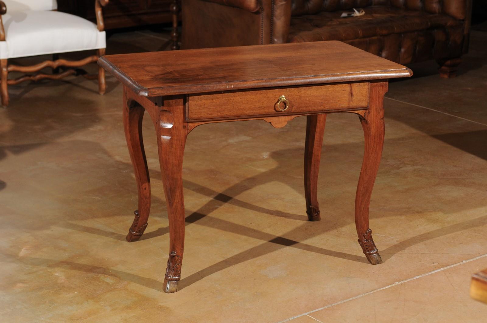 A French Louis XV style walnut side table from the mid-19th century with single drawer and hoofed feet. Born during the reign of France's last Emperor Napoleon III, this French walnut side table features a rectangular top with molded edges and