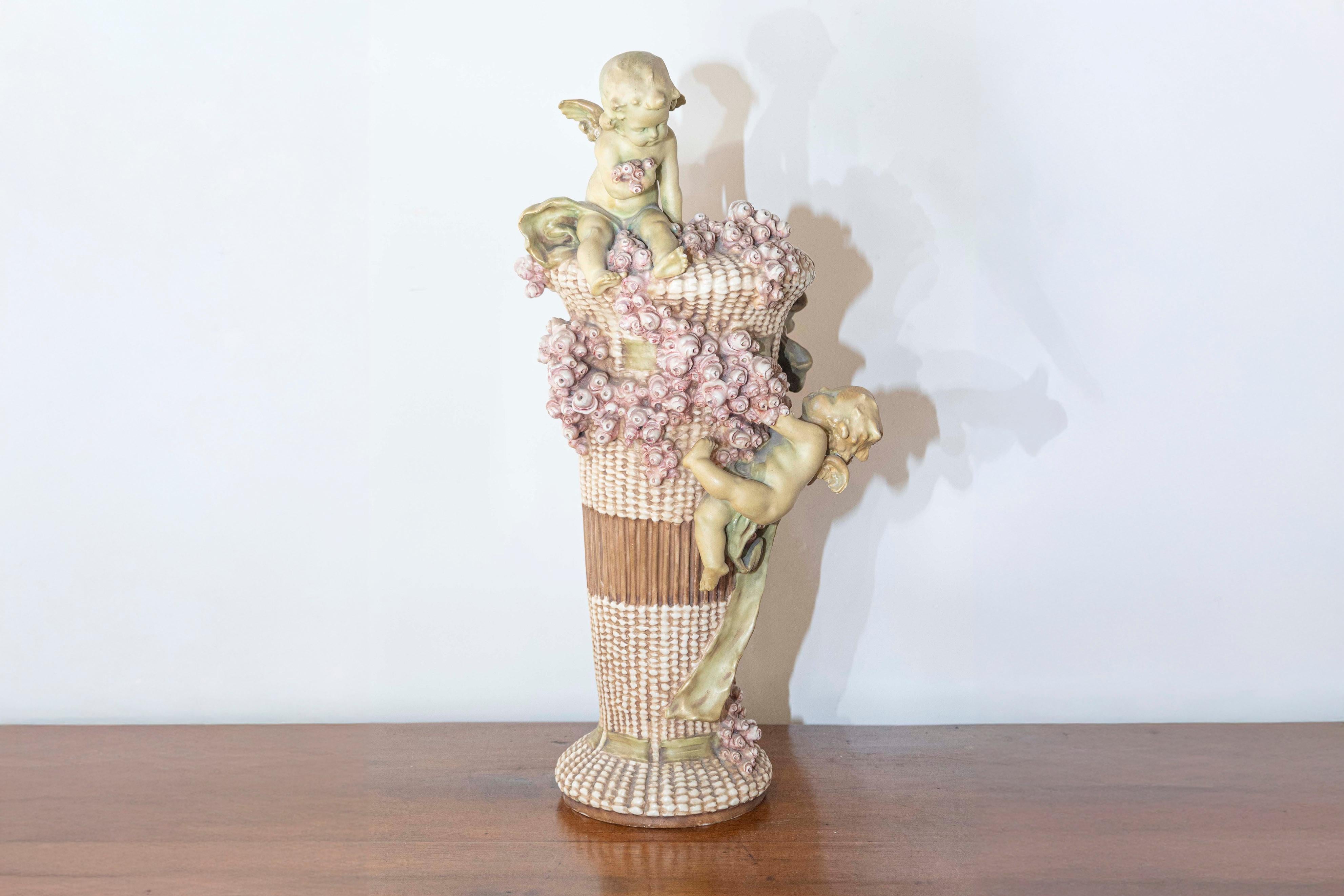 A French Napoléon III period painted terracotta vase from the mid-19th century, with cherubs playing among pink roses. Created in France during the reign of Emperor Napoléon III, this ribbon-tied vase charms us with its delightful depiction of two