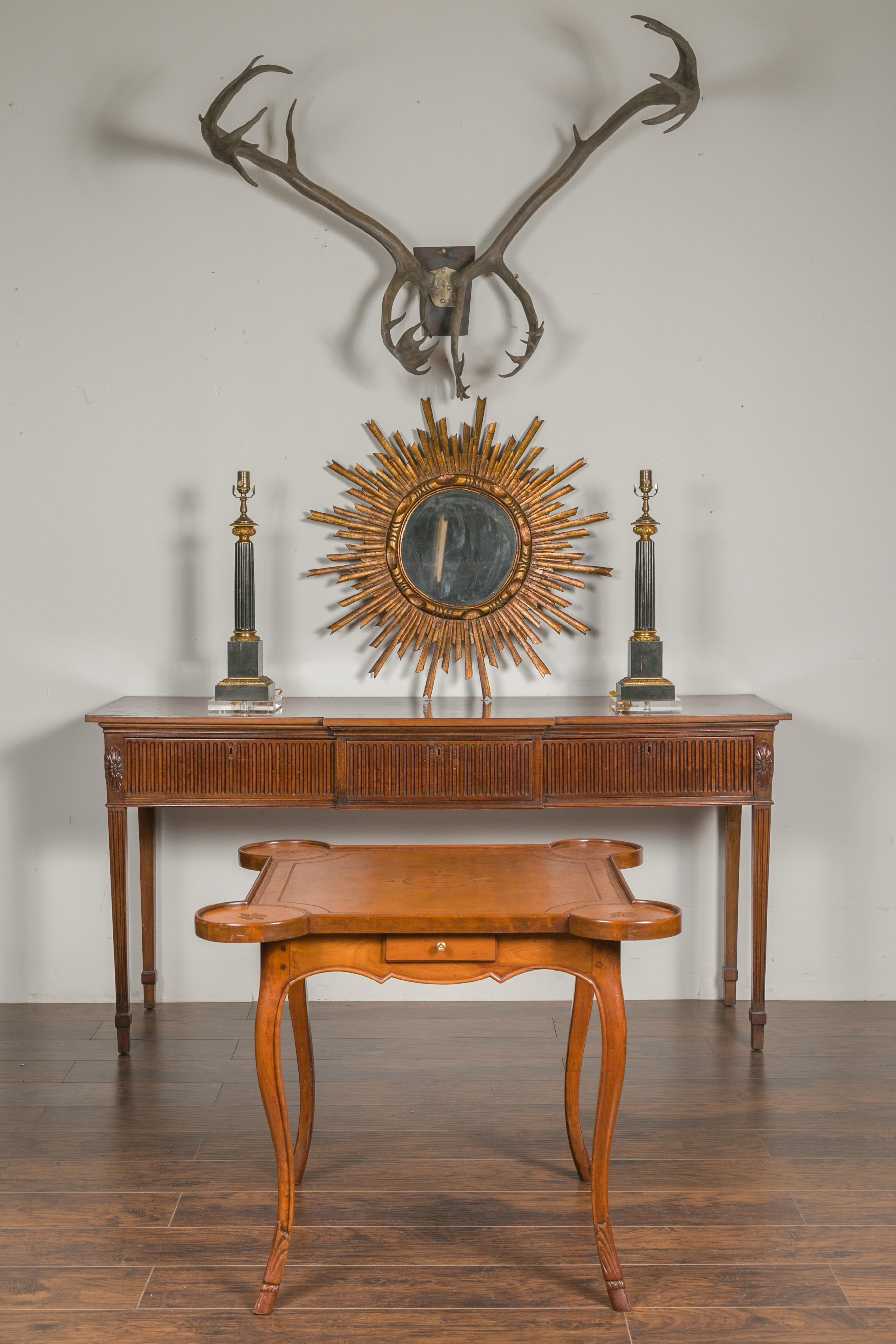 A French Napoleon III period walnut game table from the mid-19th century, with leather top and four drawers. Created in France during the reign of Emperor Napoleon III, this walnut game table features a tooled leather top with rounded corners,