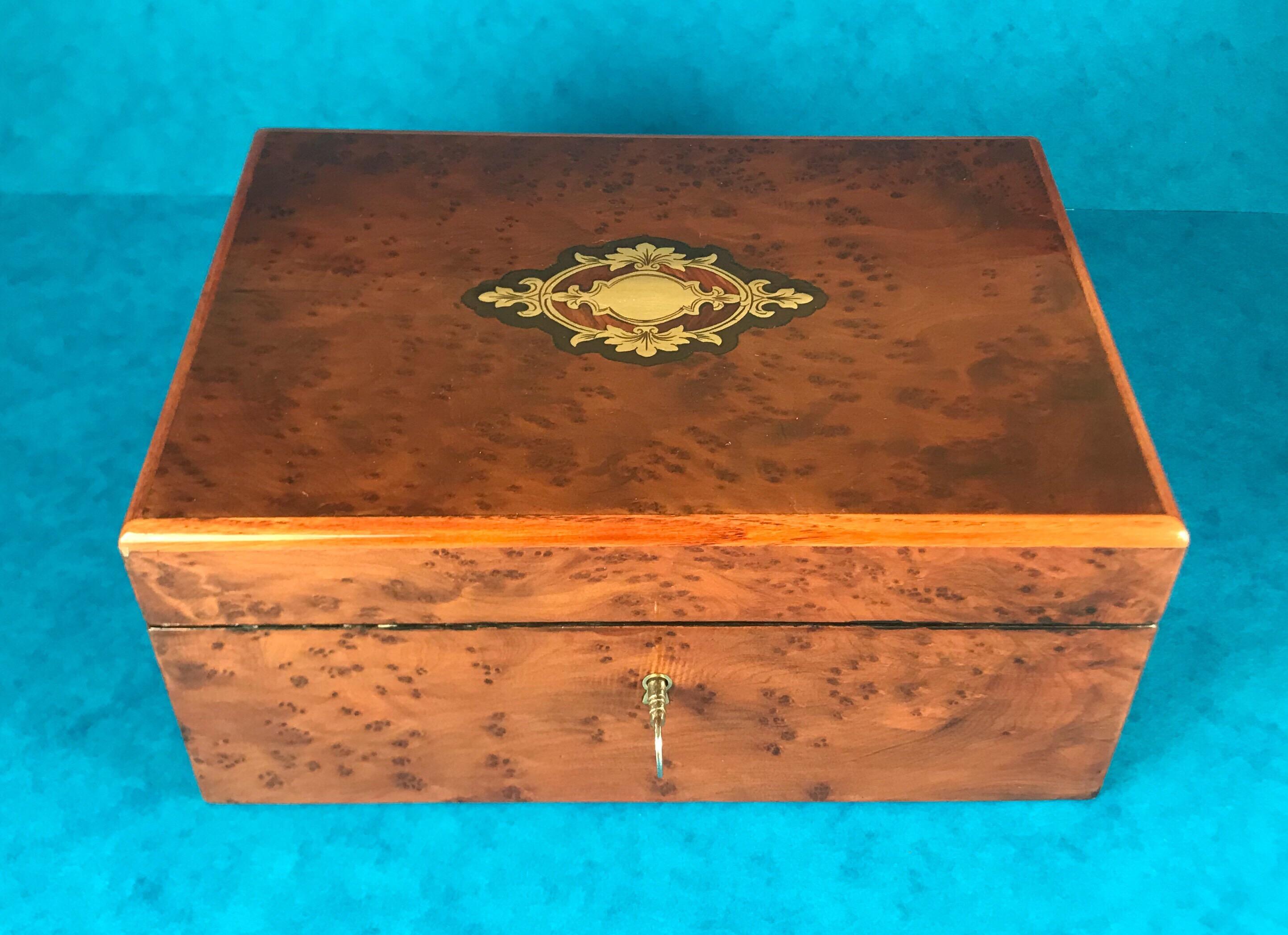 A French 1870 Burr cedar tulip wood cross banded box, it’s edged in mahogany and has a mahogany, Ebonized fruitwood and brass escutcheon to the centre. It has a relined interior and a working lock and key.
It measures 21 by 15 and stands 9.5 cm