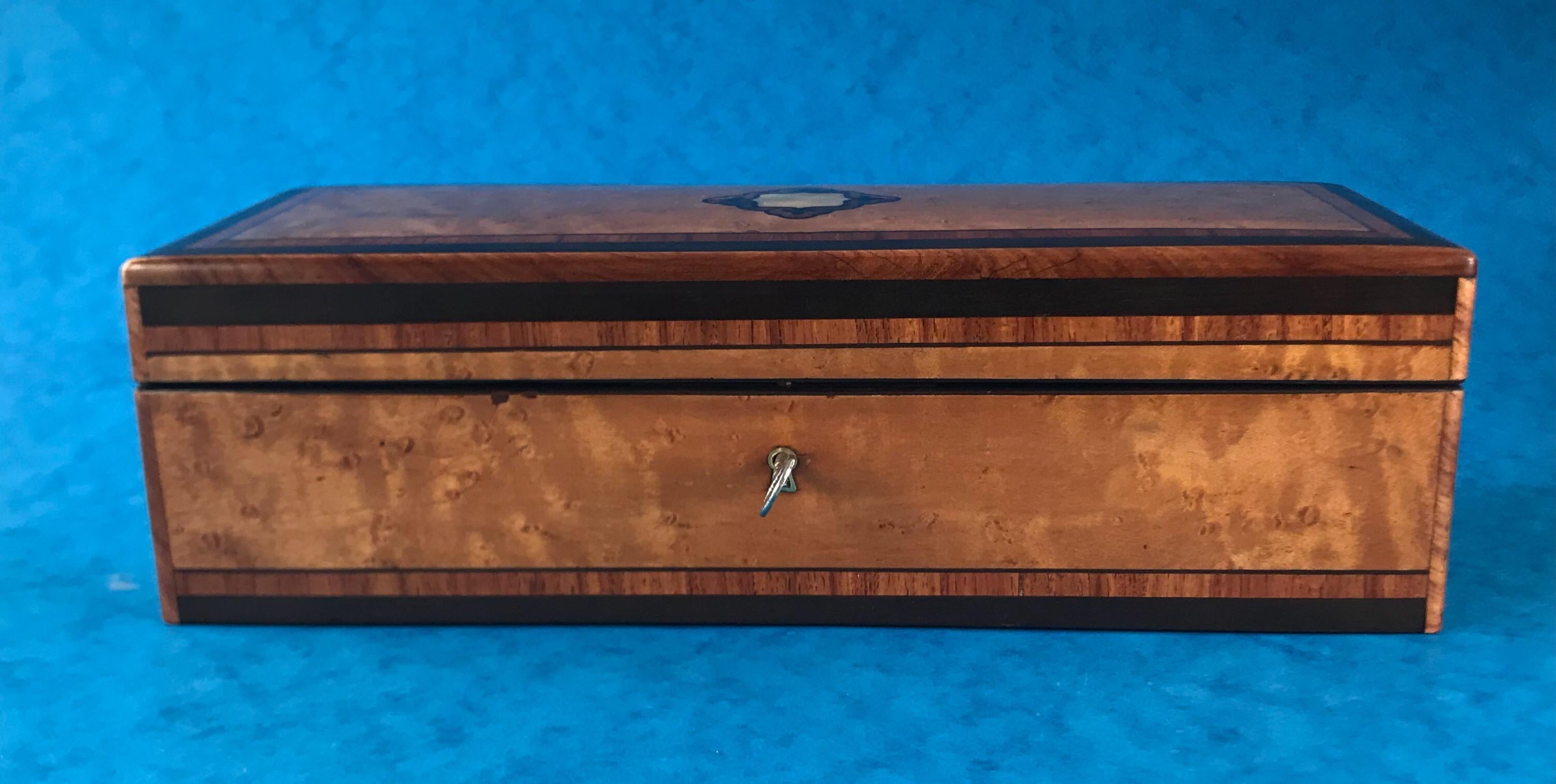 A wonderful French 1870 Burr maple, Tulipwood cross banded ,ebony inlaid glove box, with a rosewood interior and a fall down front. it has a working lock and key and it It measures 30.5 by 11.5 and stands 9.5 cm high.

