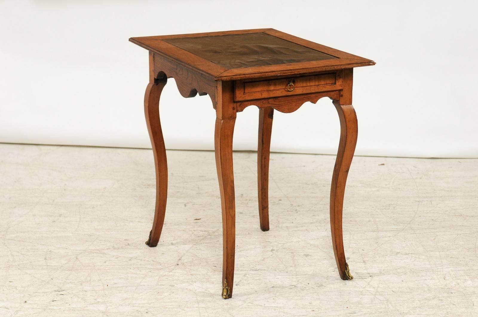 A French embossed leather top Louis XV style side table with single drawer, cabriole legs and ormolu mounts from the second half of the 19th century. This French side table features a rectangular top with inset black leather, showing the traces of
