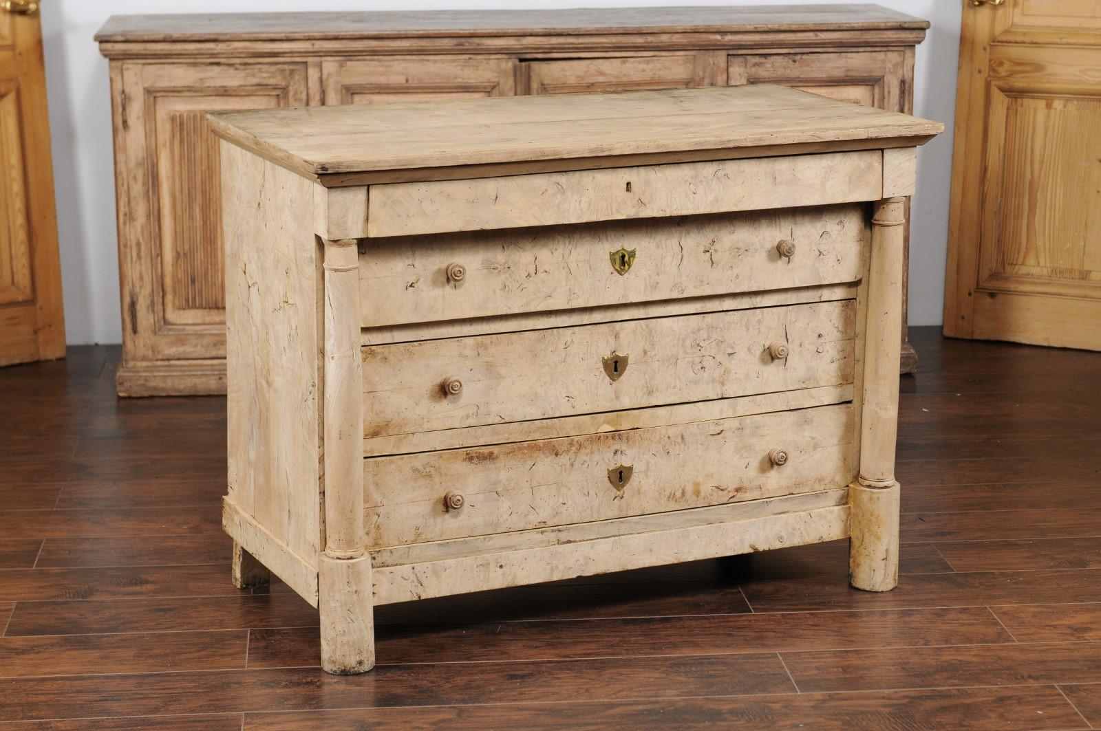 A French bleached wood Empire style four-drawer commode from the late 19th century, with columns and frieze drawer. Born at the end of the reign of France's last emperor Napoleon III, this bleached commode presents the stylistic traits of the First