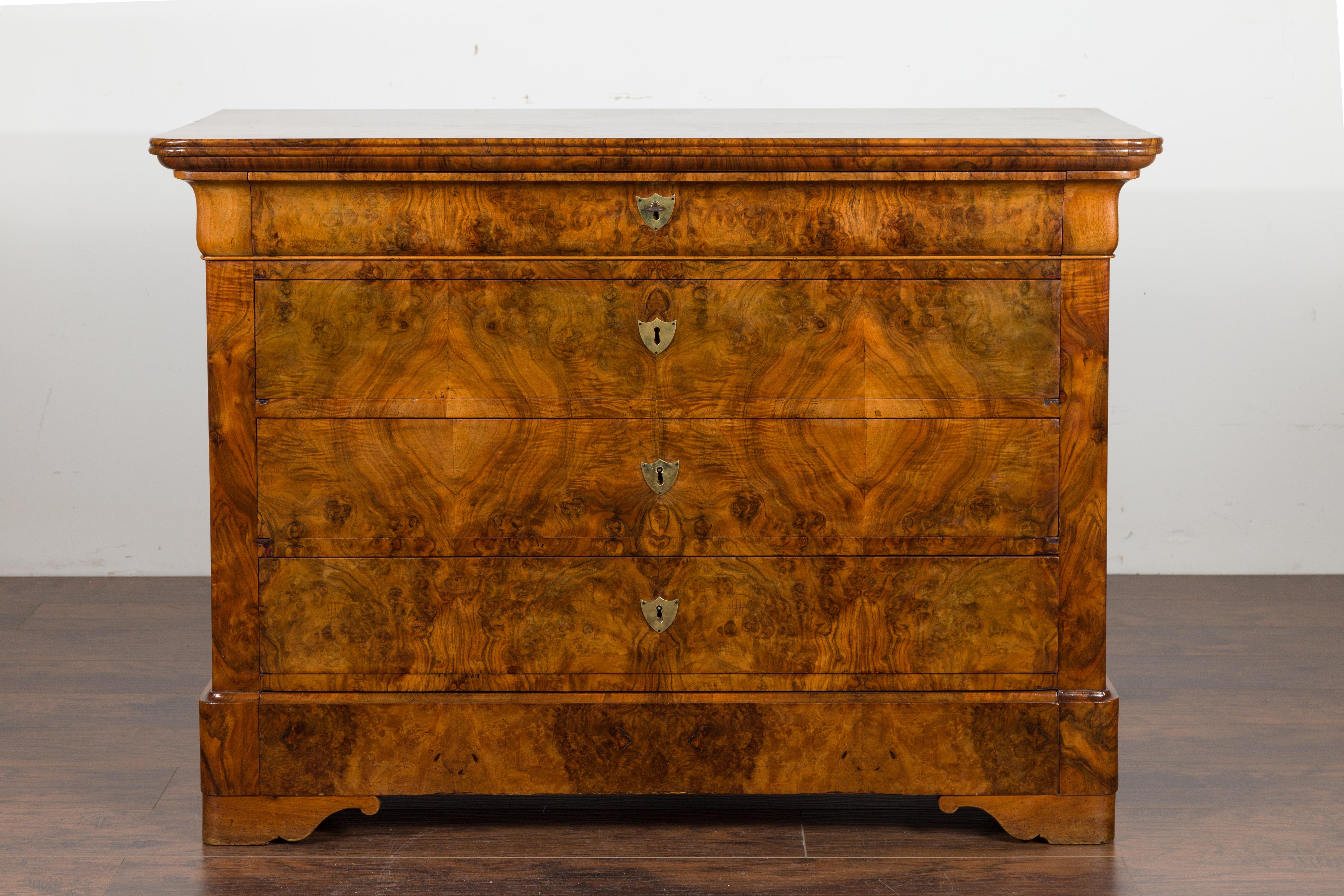 A French Louis-Philippe style walnut commode from the late 19th century, with five drawers and butterfly veneer. Created in France during the third quarter of the 19th century, this walnut commode features an exquisite veneered top sitting above