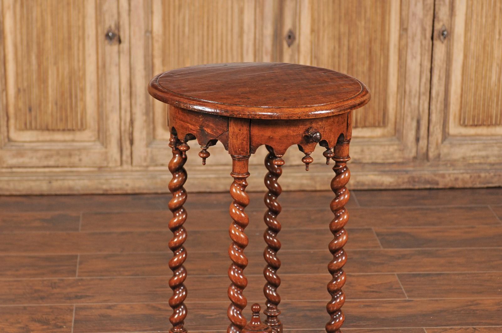 A French walnut Louis XIII style guéridon side table from the late 19th century, with single drawer and barley twist legs. Born in France at the end of Emperor Napoleon III's reign, this exquisite guéridon features a circular top sitting above a