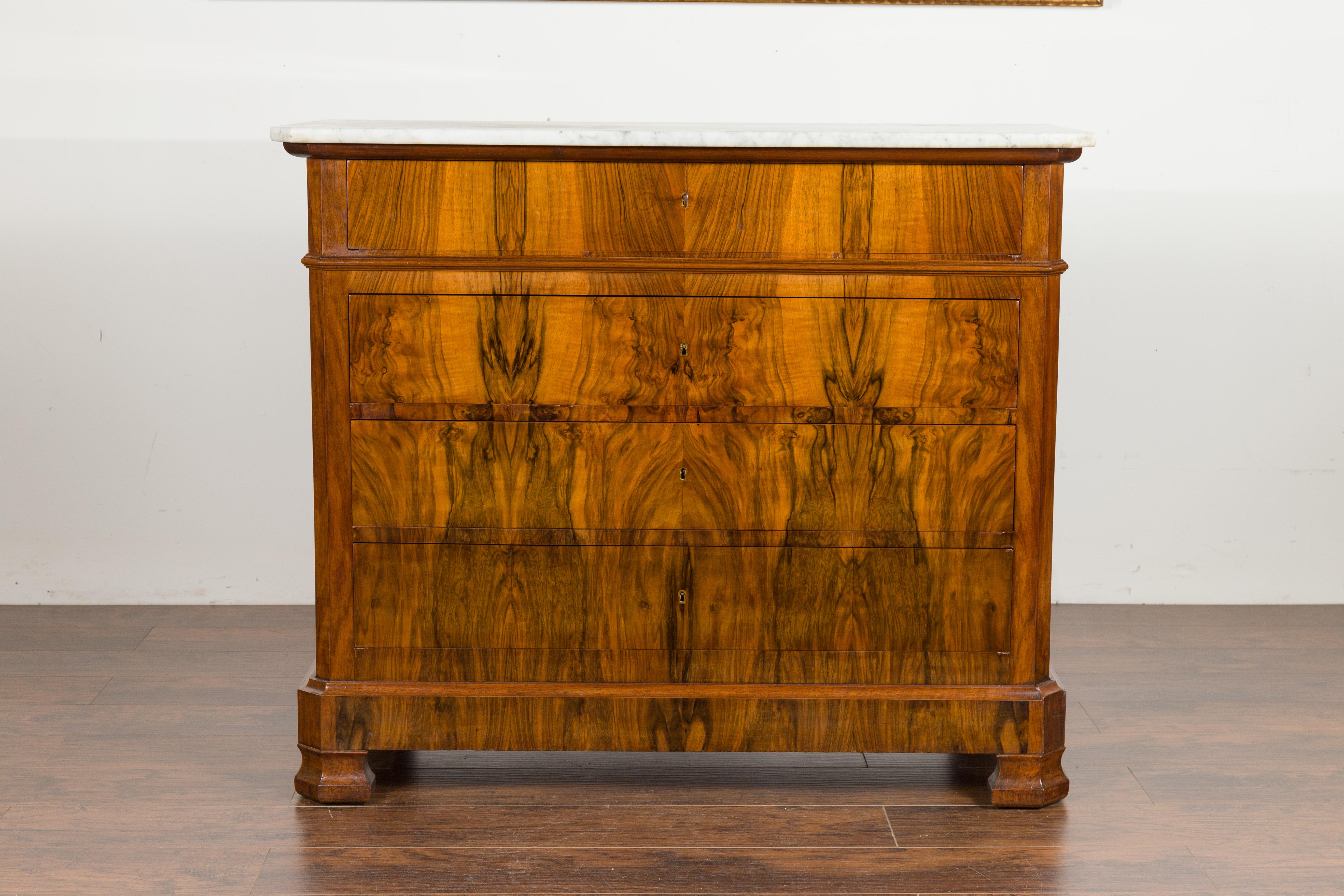 A French Napoléon III period veneered four-drawer commode from the late 19th century, with white marble top. Created in France at the end of Emperor Napoléon III's reign, this wooden commode features a rectangular white veined marble top with canted