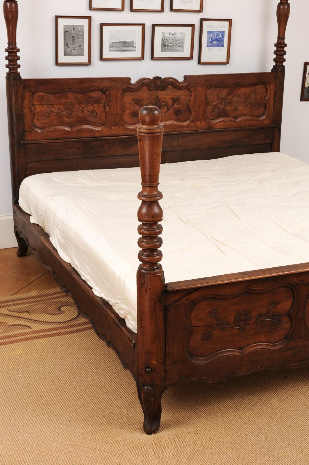 A French Napoléon III period walnut bed from the late 19th century, with carved floral motifs. Showcasing exceptional dimensions larger than a Queen size, this French walnut bed is offered with a custom mattress measuring 68