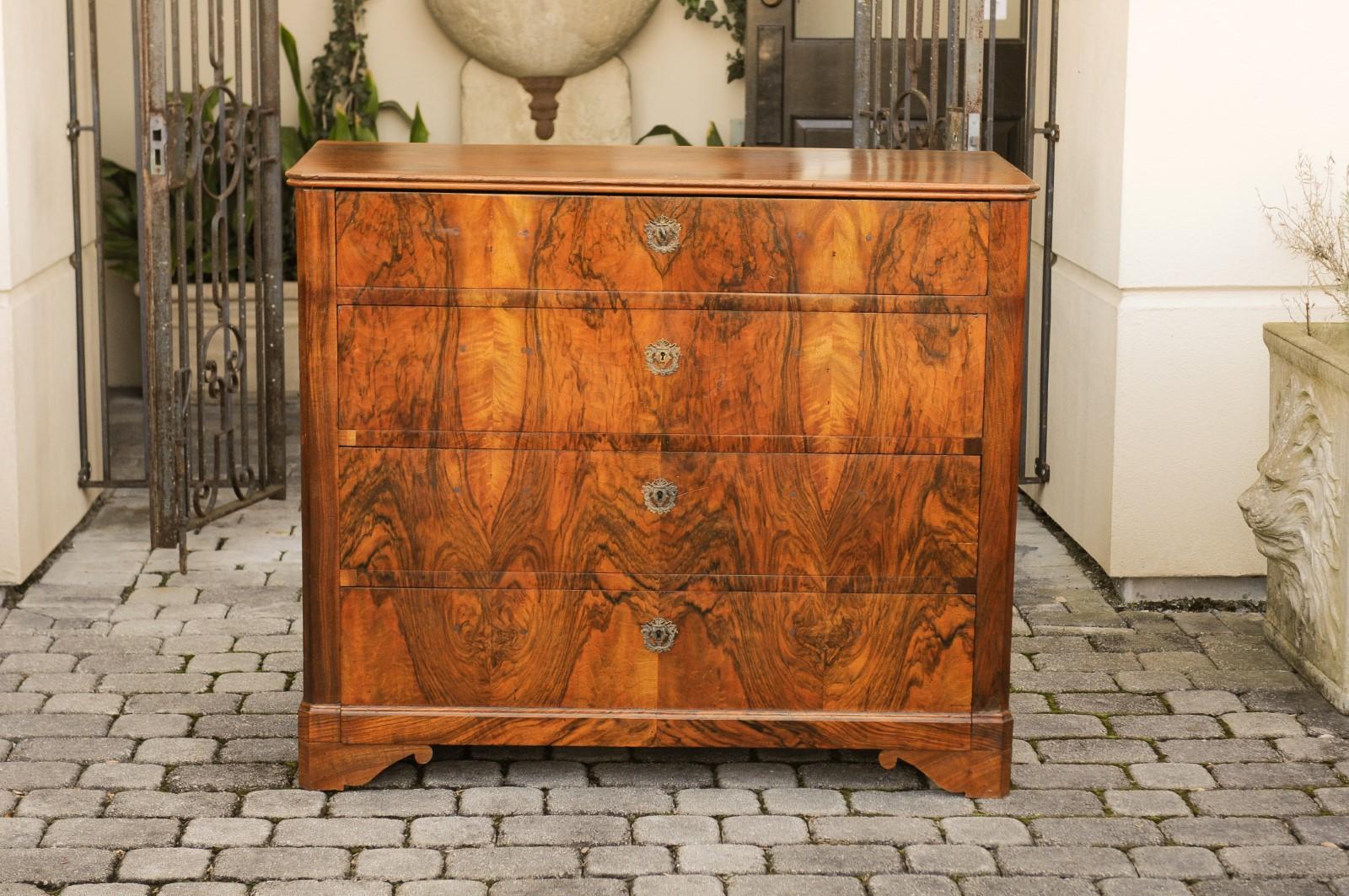A French walnut four-drawer commode from the third quarter of the 19th century, with bookmarked veneer and bracket feet. Born in France at the end of the reign of France's last Emperor Napoleon III, this exquisite commode features a rectangular top