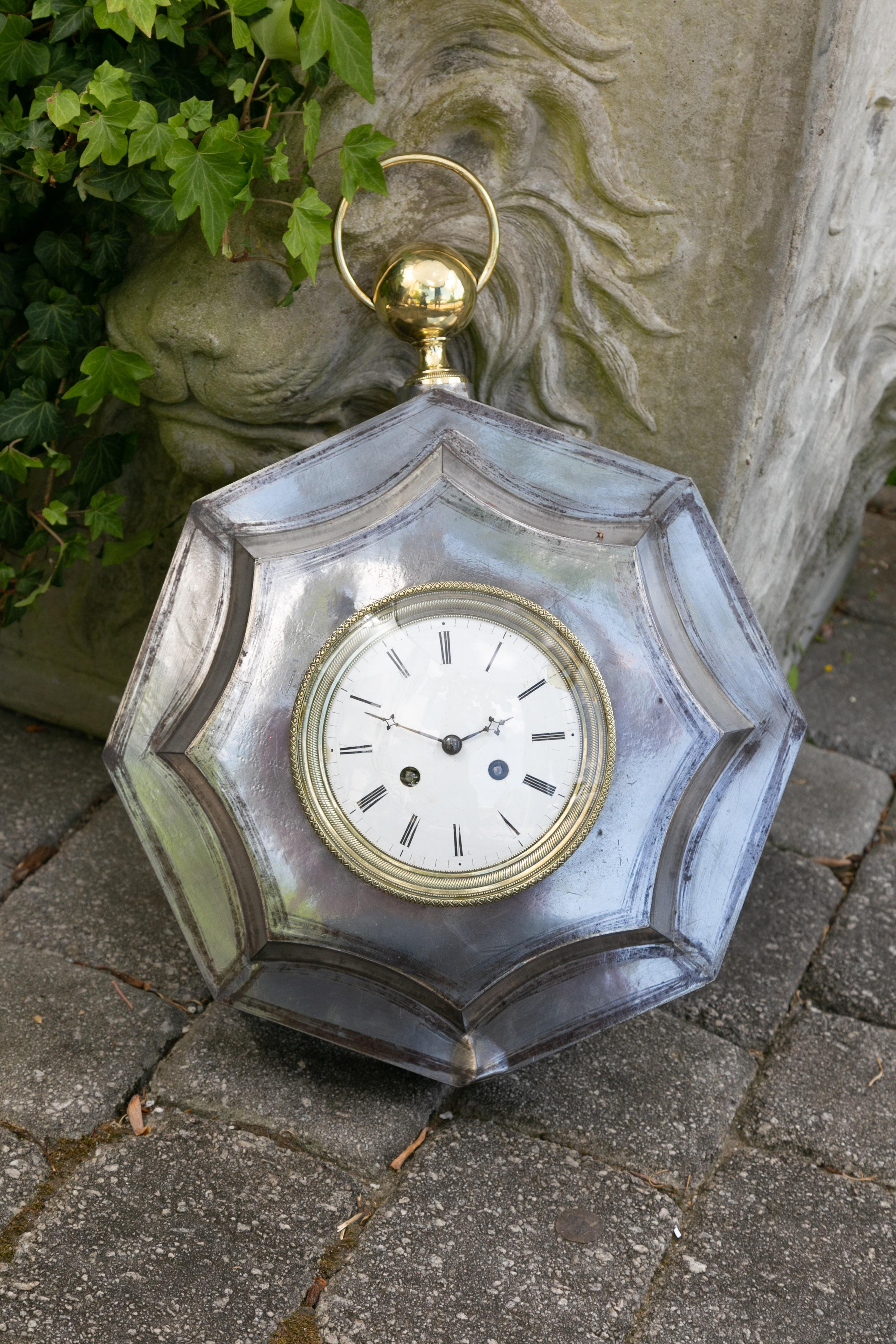 A French polished steel octagonal wall clock from the late 19th century, with brass accents. Created in France at the end of the reign of Emperor Napoleon III's reign, this wall clock features an octagonal polished steel frame highlighted with brass