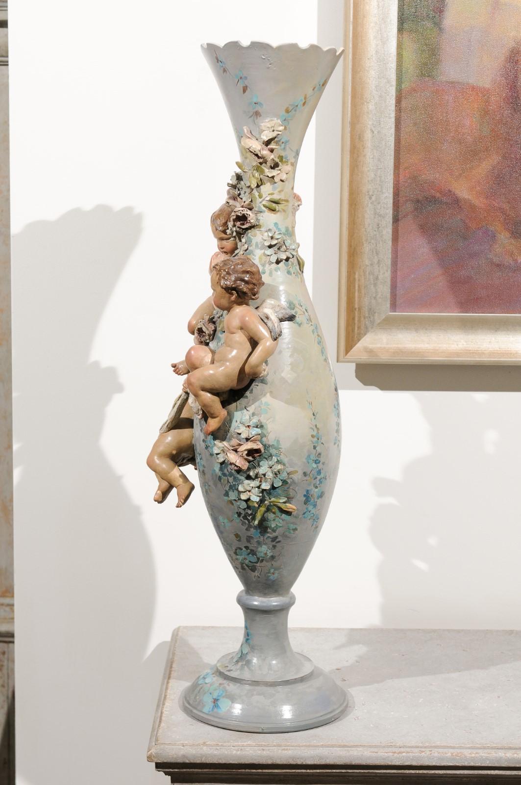 19th Century French 1870s Slender Majolica Vase with Floral Décor and High-Relief Cherubs For Sale