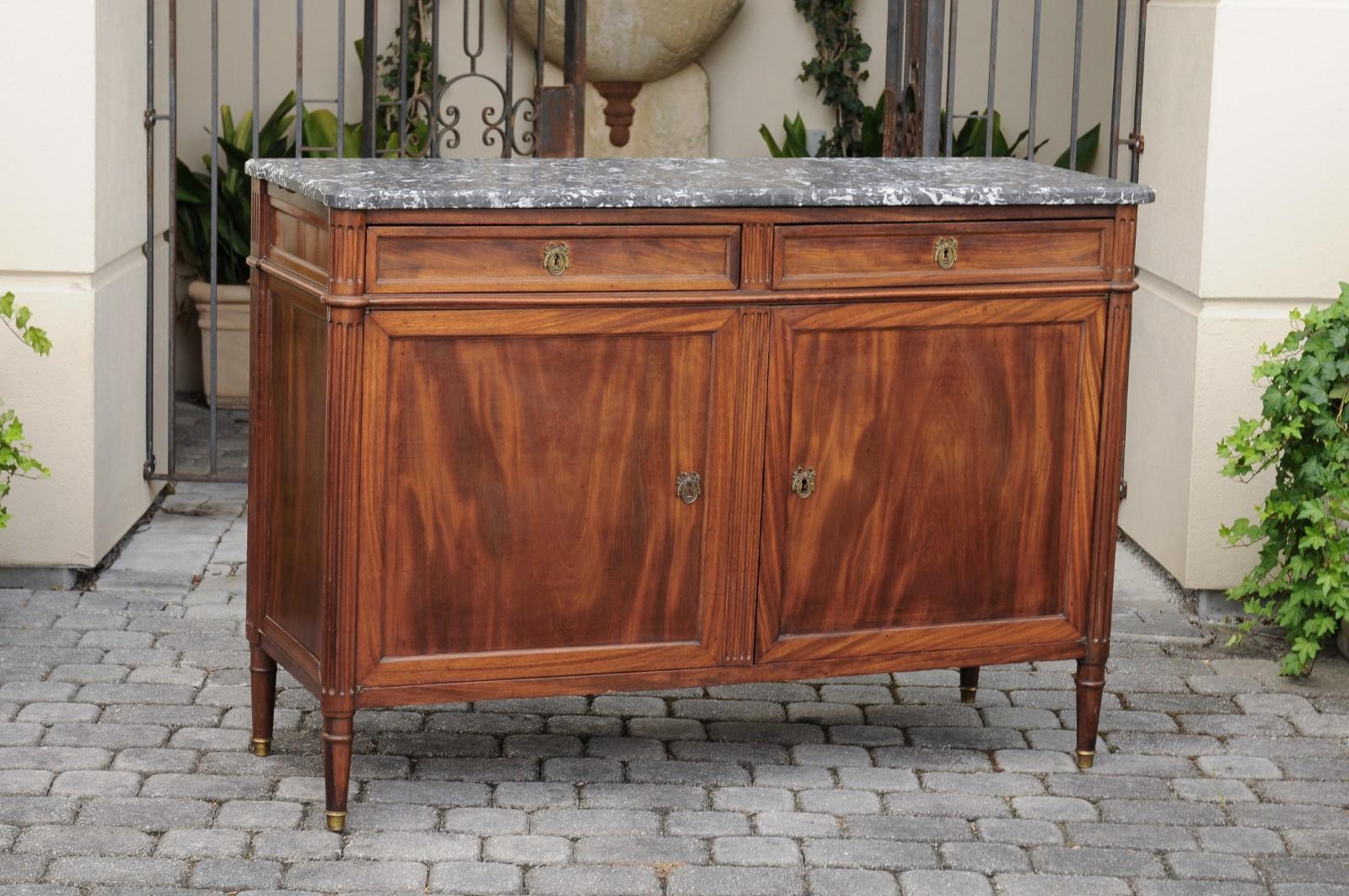A French walnut buffet from the late 19th century, with grey marble top, two drawers and two doors. Born in France during the third quarter of the 19th century, this walnut buffet features a grey veined marble top, sitting above two dovetailed
