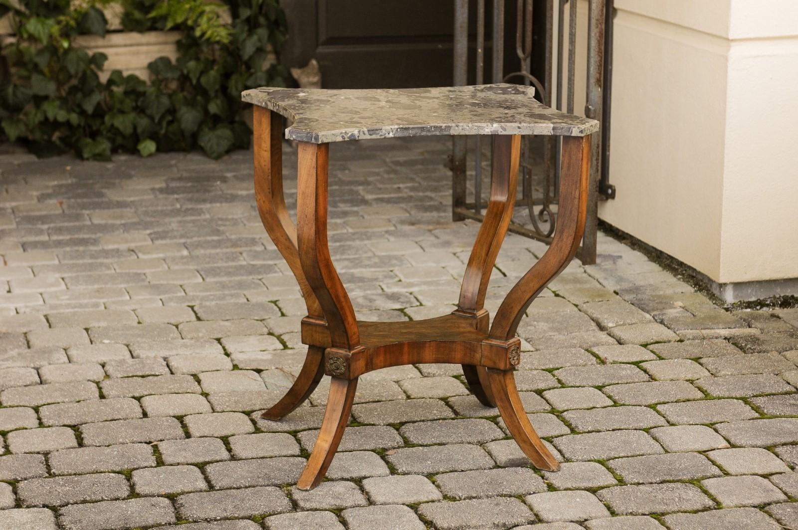 A French walnut side table from the third quarter of the 19th century, with shaped marble top and narrow shelf. Born in the later years of France's last Emperor Napoleon III, this exquisite side table features a variegated marble top with canted