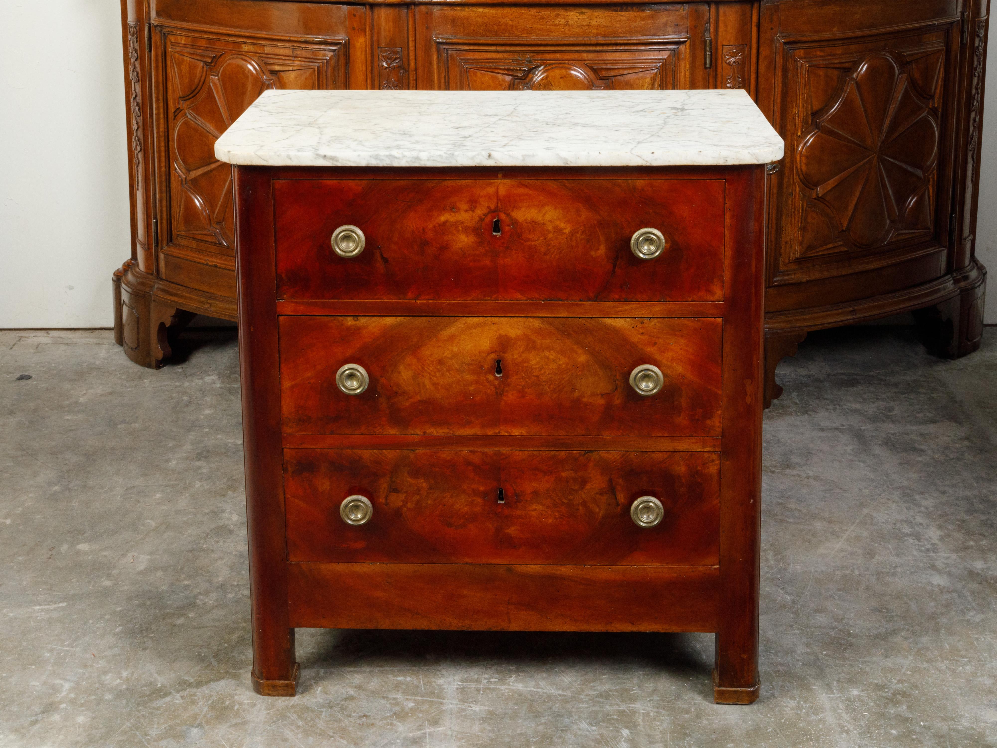 A French walnut commode from the late 19th century, with three drawers and white marble top. Created in France at the end of Emperor Napoléon III's reign, this commode features a white veined rectangular top with rounded corners in the front,