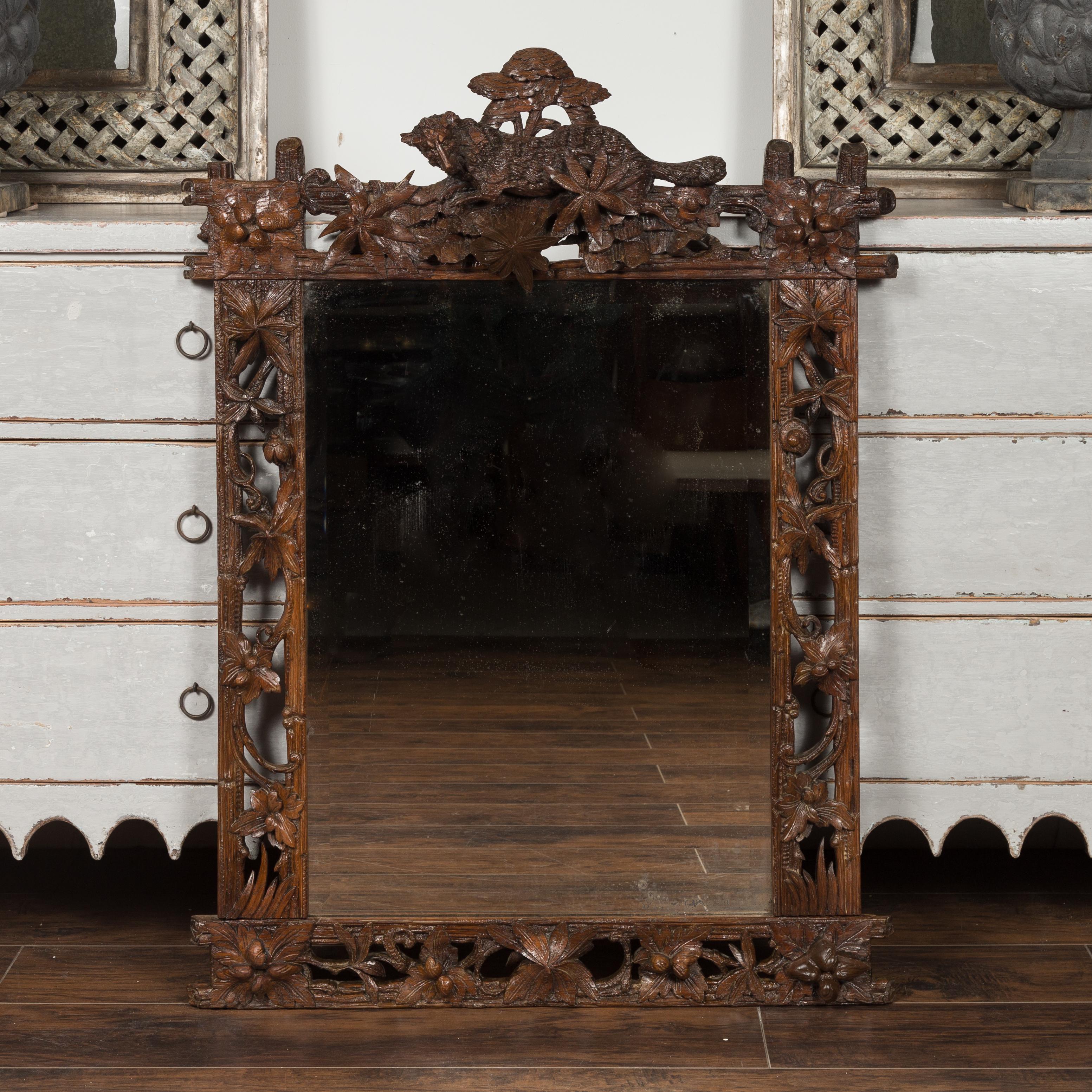 A French Black Forest carved wood mirror from the late 19th century, with fox and foliage motifs. Created in France during the last quarter of the 19th century, this Black Forest mirror features a rectangular frame adorned with exquisite carvings