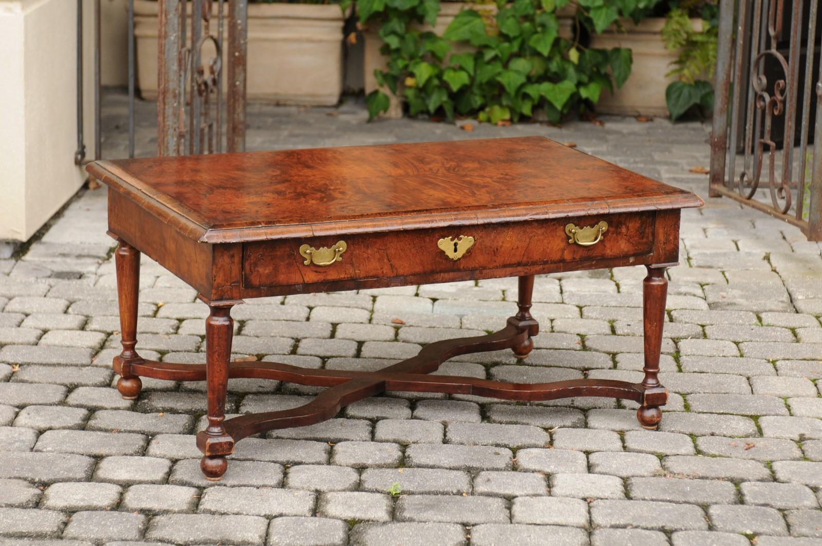 A French burl walnut coffee table from the late 19th century, with long drawer, turned legs and X-form cross stretcher. Born in the later years of the 19th century, at a time when the Impressionists were roaming the countryside looking for their