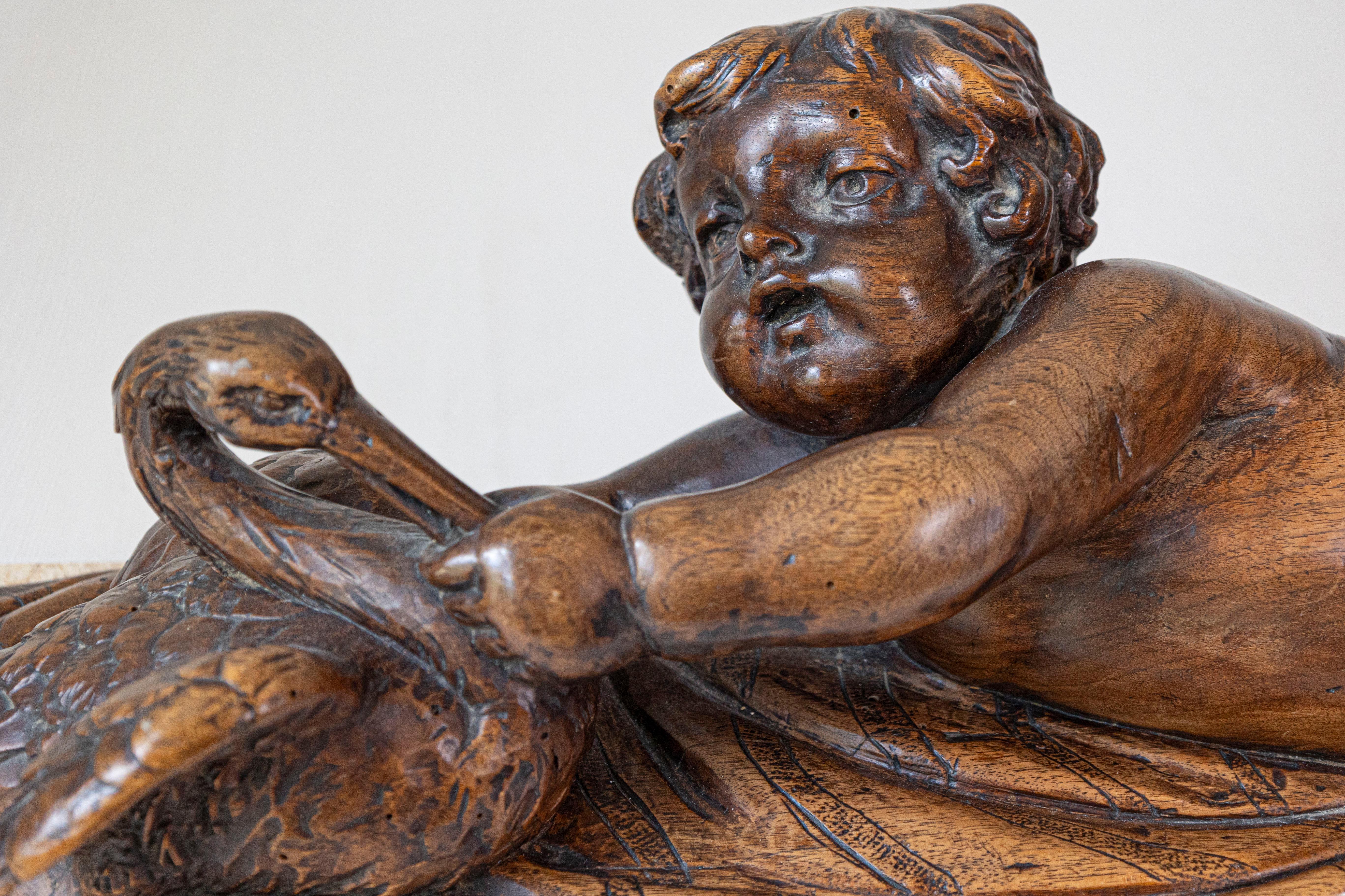 Intagliato Putto in noce intagliato del 1880 che nutre un cigno Gruppo scolpito su base di marmo in vendita