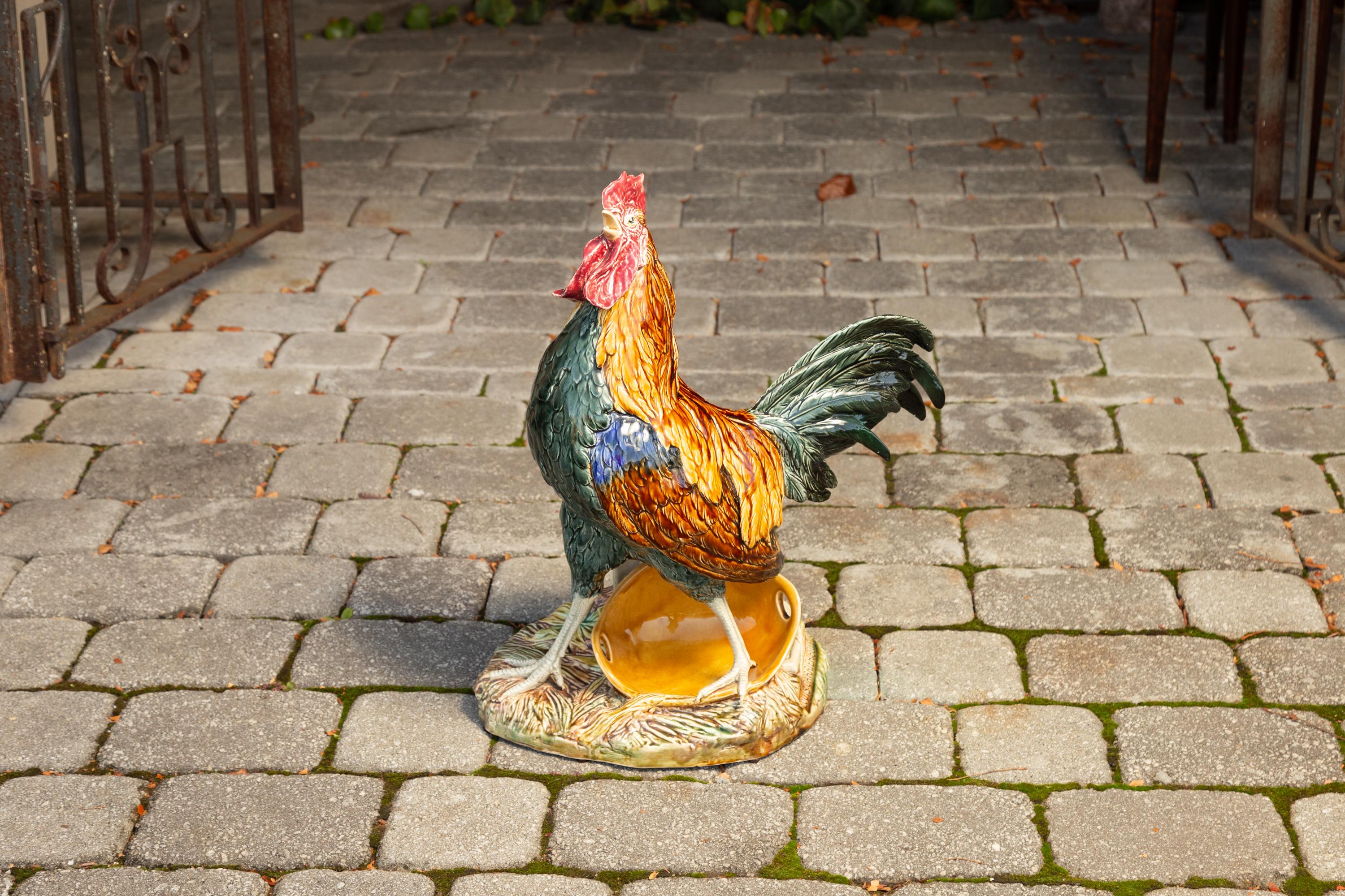 A French Choisy-le-Roi glazed majolica rooster from the late 19th century signed Louis-Robert Carrier-Belleuse. Born in France during the later years of the 19th century, this monumental rooster captures our attention with its exquisite polychromy