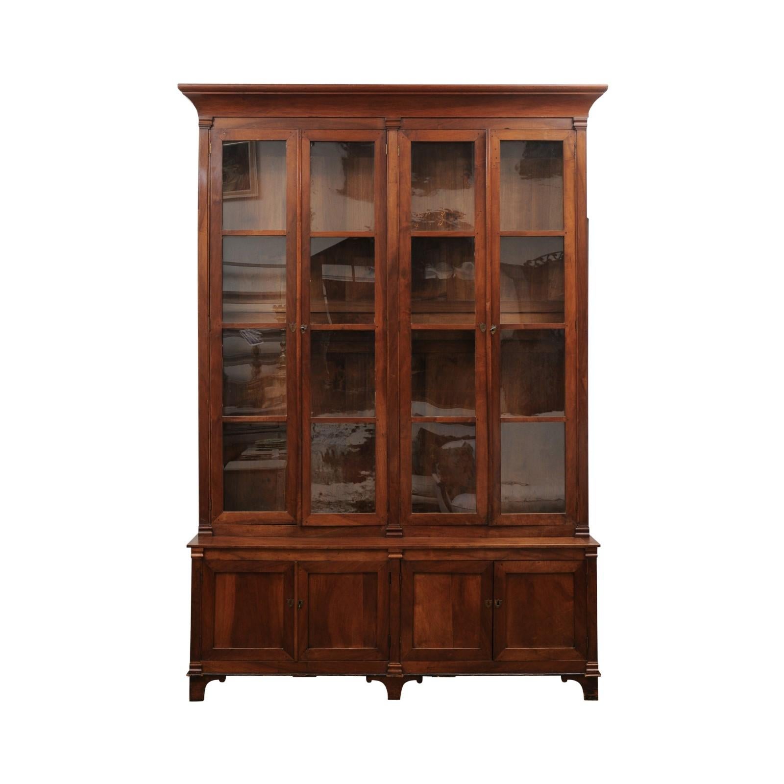 A large French Louis XVI style wooden bookcase from the late 19th century, with two pairs of glass doors, two pairs of wooden doors and Doric pilasters. Created in France during the last quarter of the 19th century, this Louis XVI inspired bookcase