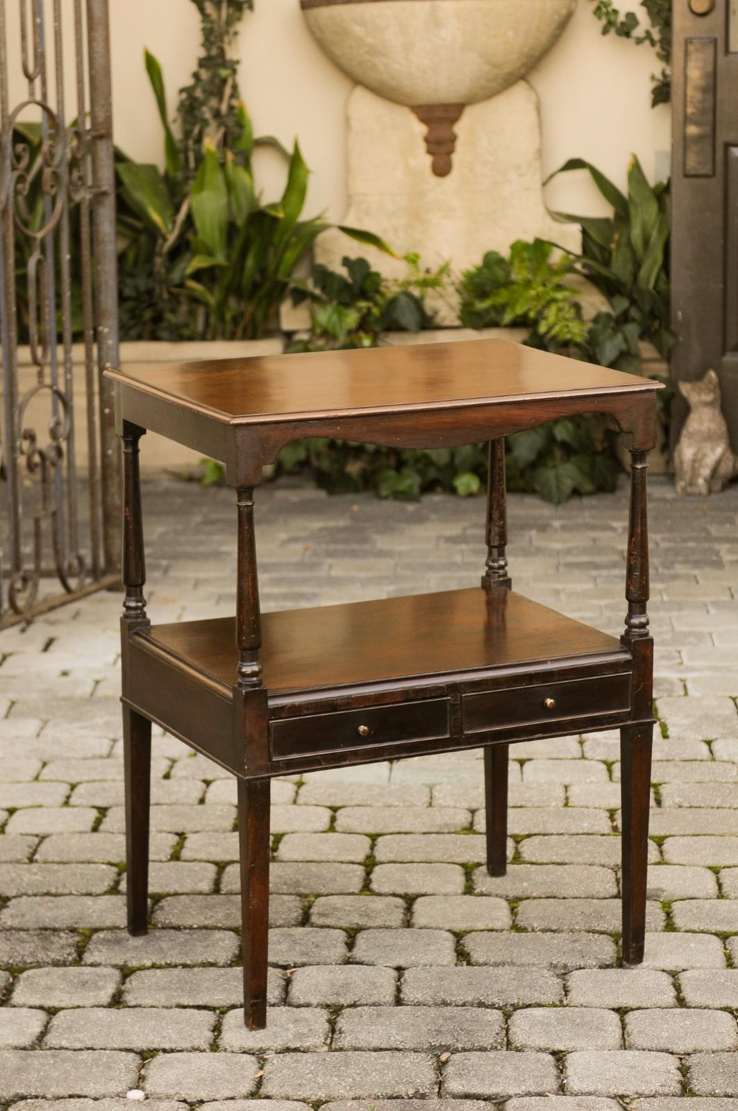 A French mahogany tiered table from the late 19th century with valanced apron, lower shelf and two drawers. Born in France during the later years of the politically dynamic 19th century, this exquisite French tiered table features a rectangular top,