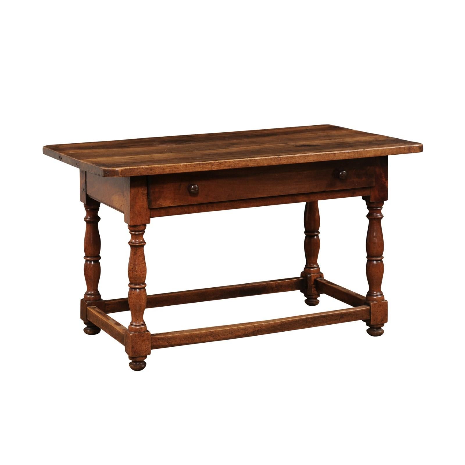 A French walnut console table from the late 19th century, with long single drawer, turned baluster legs and low side stretchers. Created in France during the last quarter of the 19th century at a time when the Impressionists were roaming the
