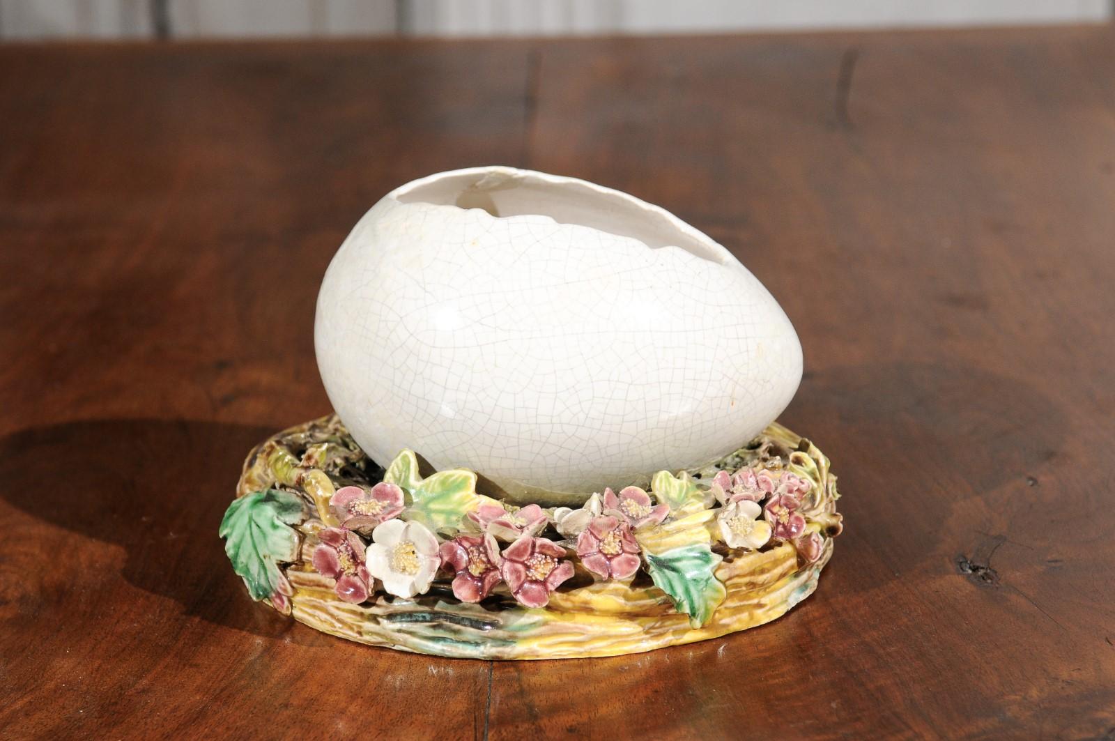 A French barbotine majolica egg from the late 19th century, with floral motifs. Born in France during the Belle-Époque era, this majolica egg features an exquisite barbotine décor depicting pastel flowers and foliage presenting red, green, yellow