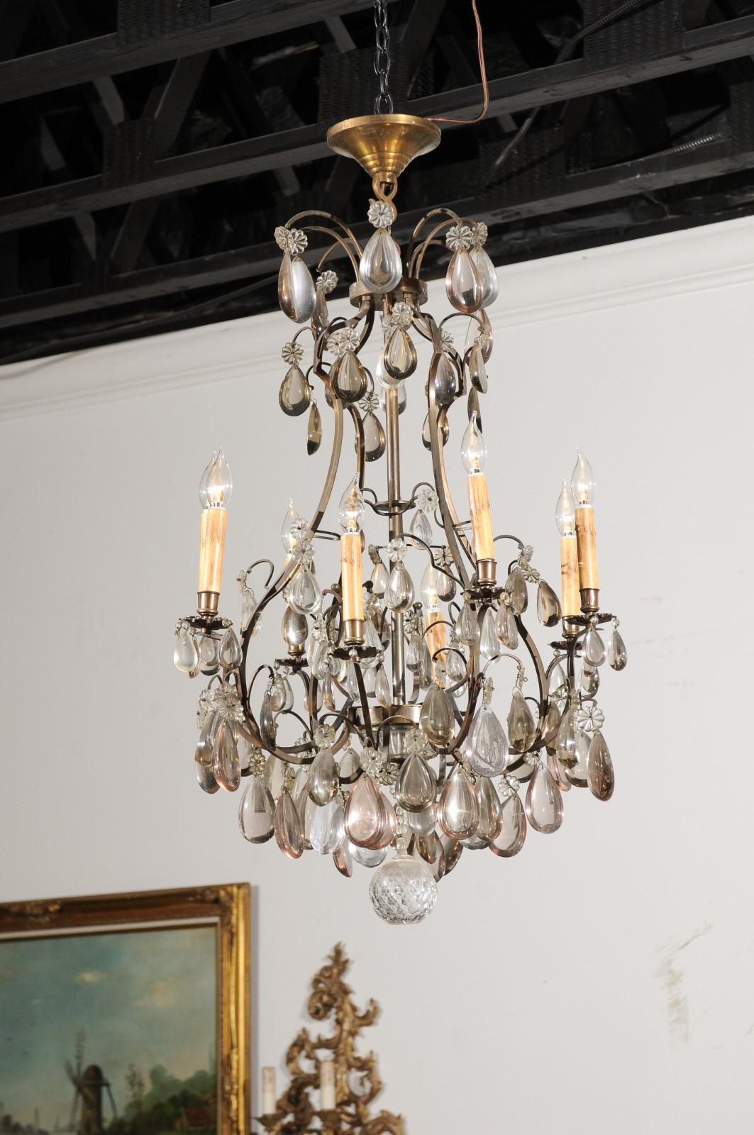 A French eight-light crystal chandelier from the late 19th century, with steel armature and smoky crystals. Born in France during the Belle Époque era, this exquisite chandelier features a scrolling steel armature supporting a variety of clear and