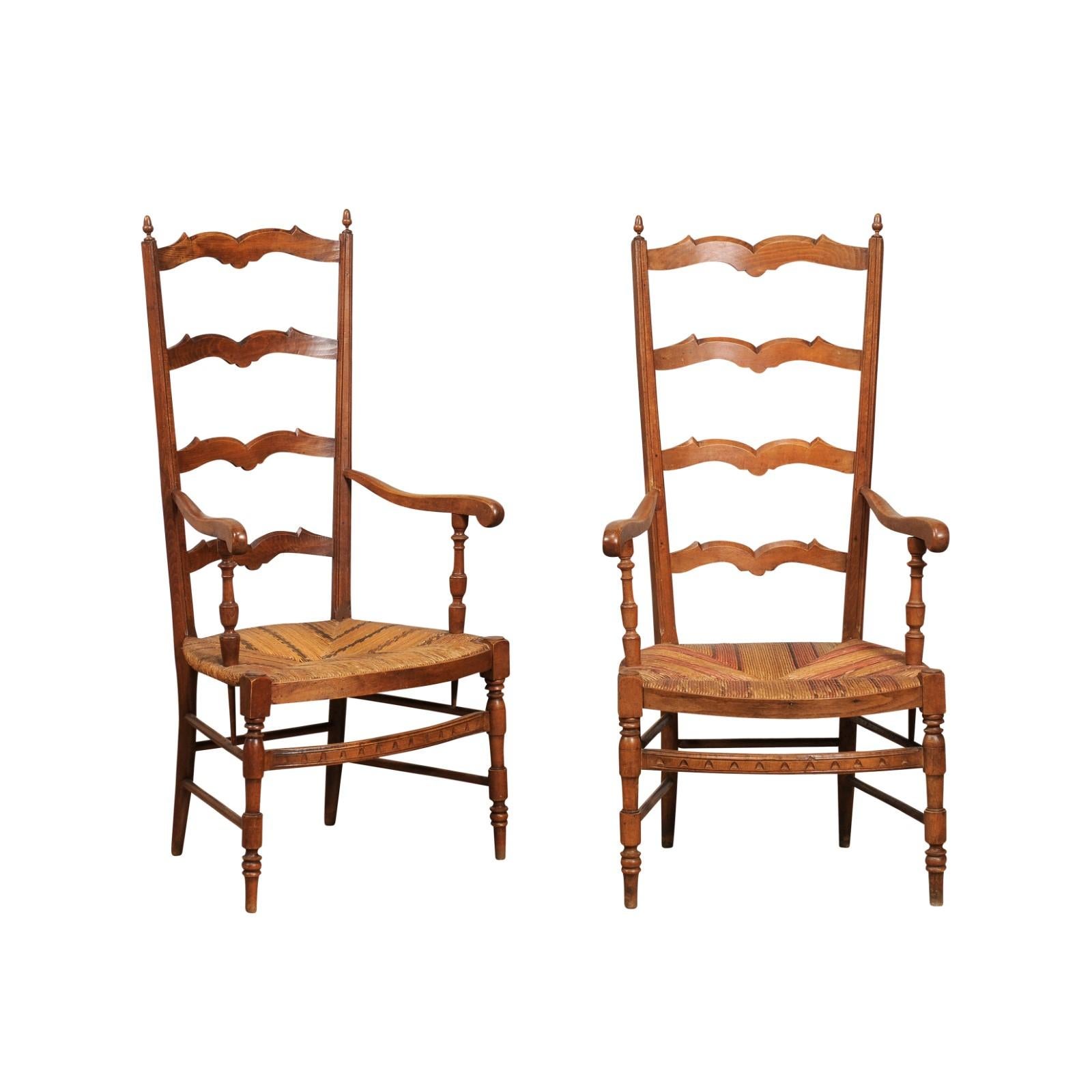 A pair of French fruitwood ladder back chairs from circa 1890 with woven straw seats, turned legs and bow arched bars. Embrace the rustic charm and timeless elegance of these French fruitwood ladder back chairs from circa 1890. Their honeyed tones,