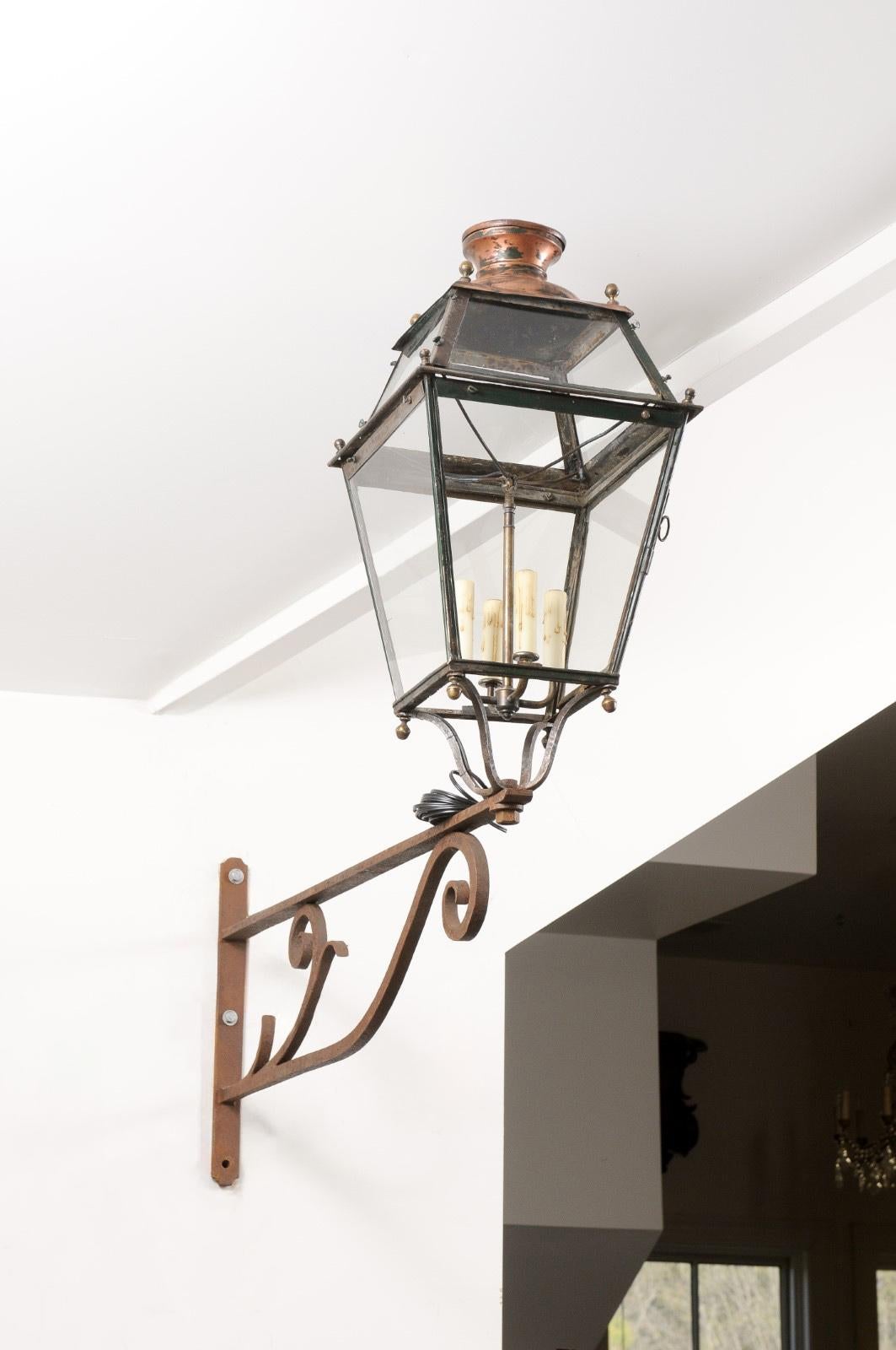 Farol de pared francés de hierro de finales del siglo XIX, con cuatro luces, paneles de cristal y ménsula con volutas. Creada en Francia durante la última década del siglo XIX, en una época en la que los impresionistas recorrían el campo en busca de