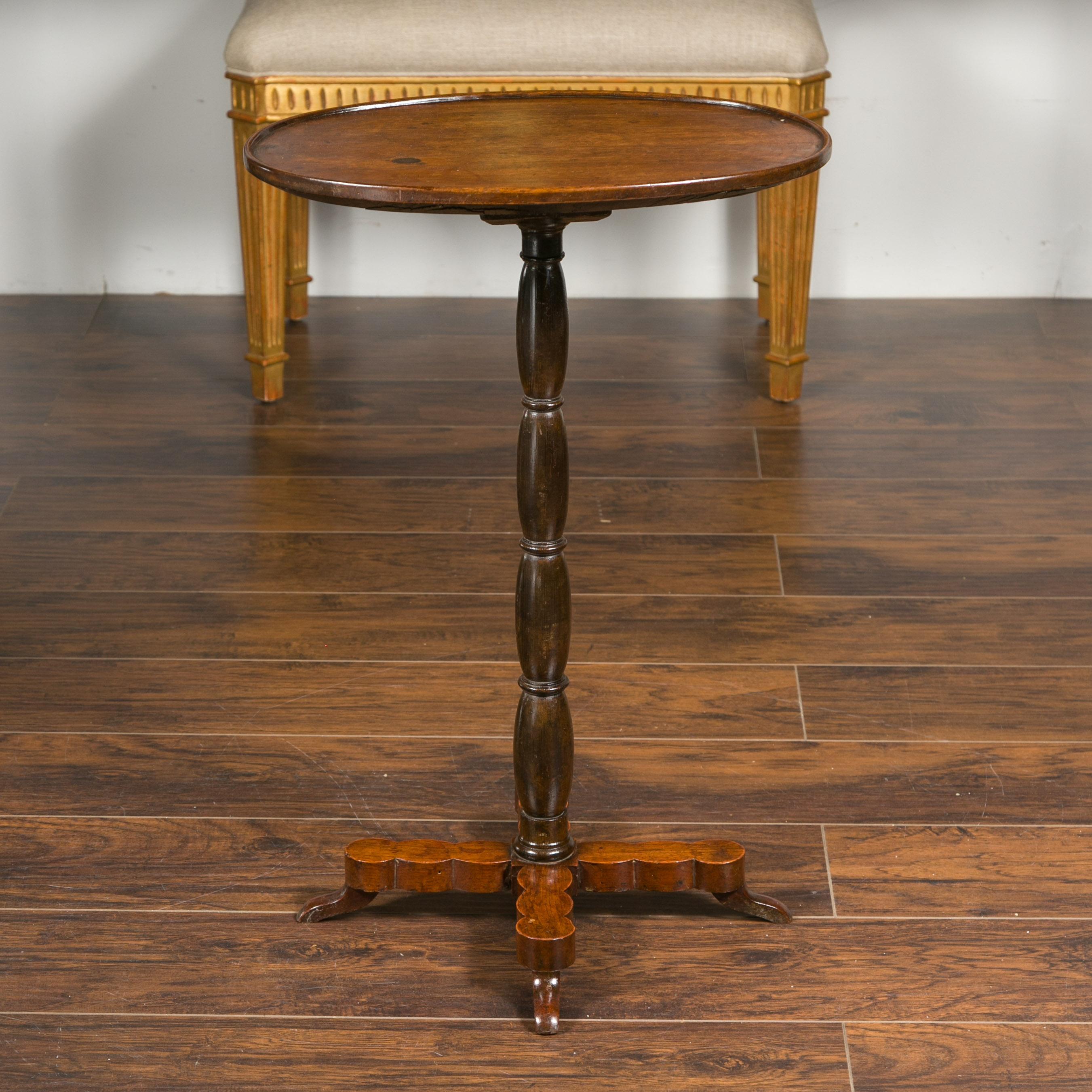 A French walnut guéridon table from the late 19th century, with oval top and turned pedestal base. Crafted in France during the last quarter of the 19th century, this walnut side table features an oval top with slightly raised edges, sitting above a