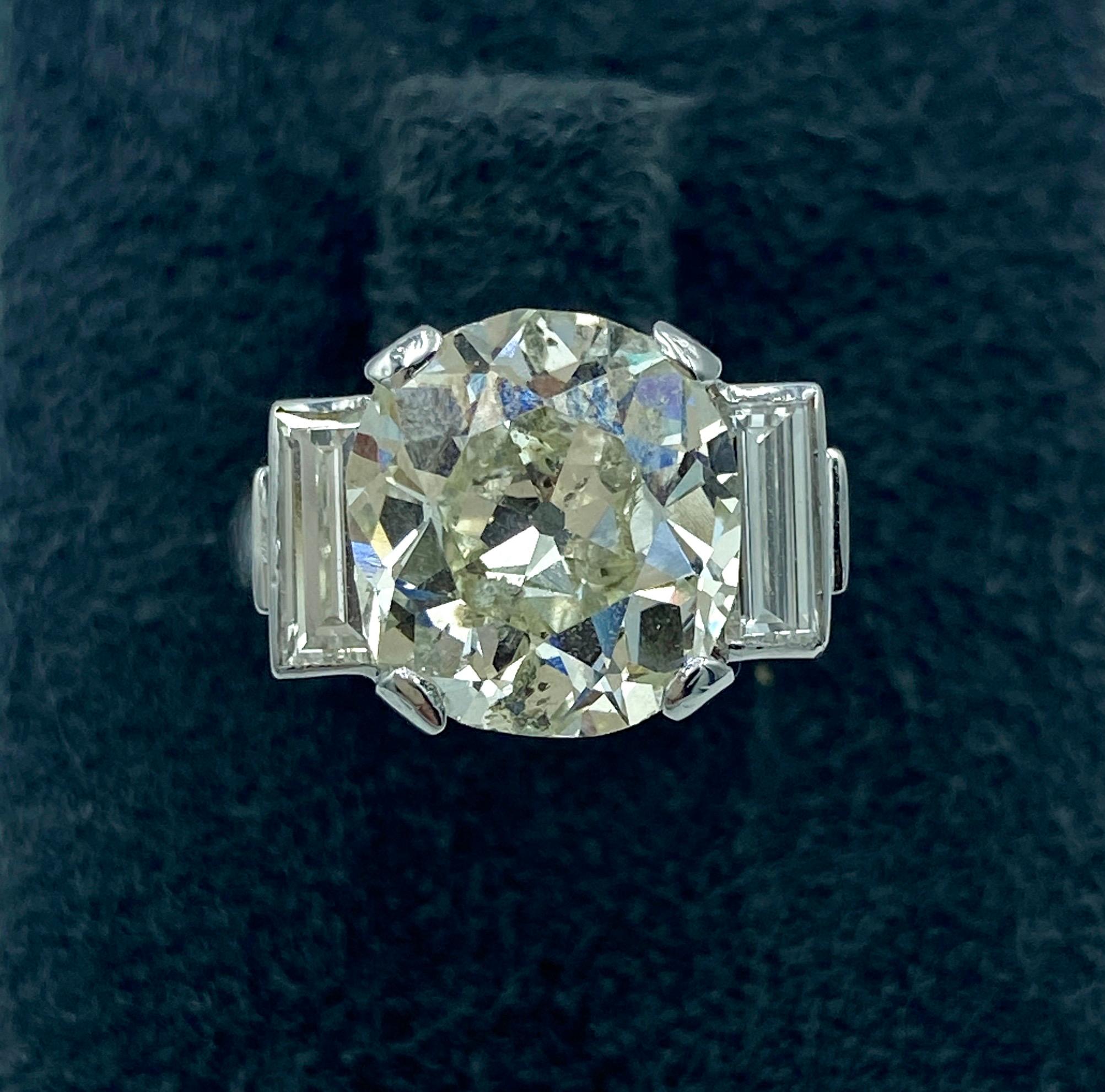An outstanding French 1890's platinum engagement ring with an old mine cut centre diamond of 4.82 carat and 2 baguettes of 0.6 carat. The centre stone is H-I colour and SI clarity and the baguettes are E-F colour and VS clarity. Photographs of the