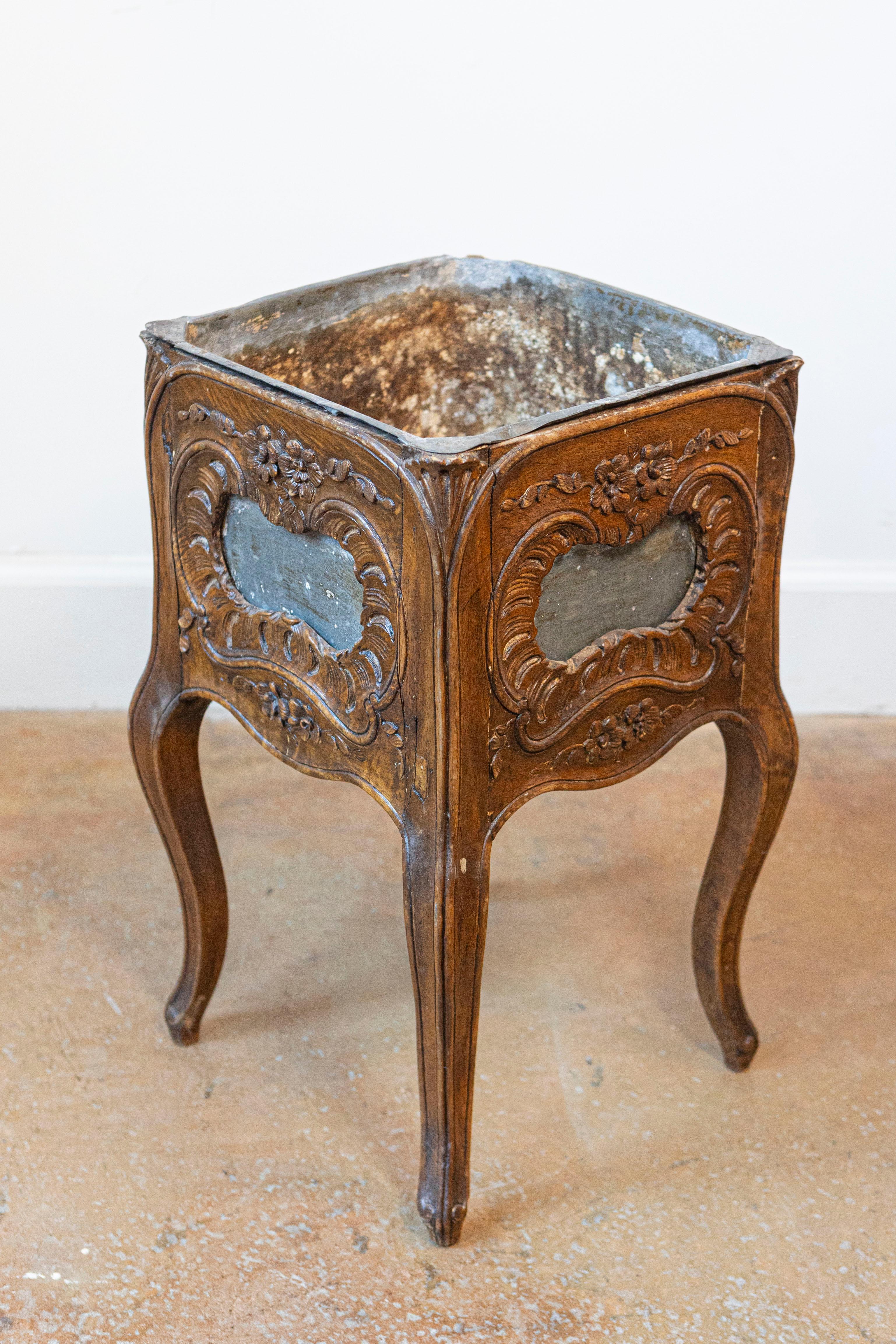 Fioriera in noce di epoca Rococo Revival francese della fine del XIX secolo, con motivi Rocailles intagliati e rivestimento in latta. Creata in Francia nell'ultimo quarto del XIX secolo, questa fioriera in noce presenta un corpo di forma quadrata,