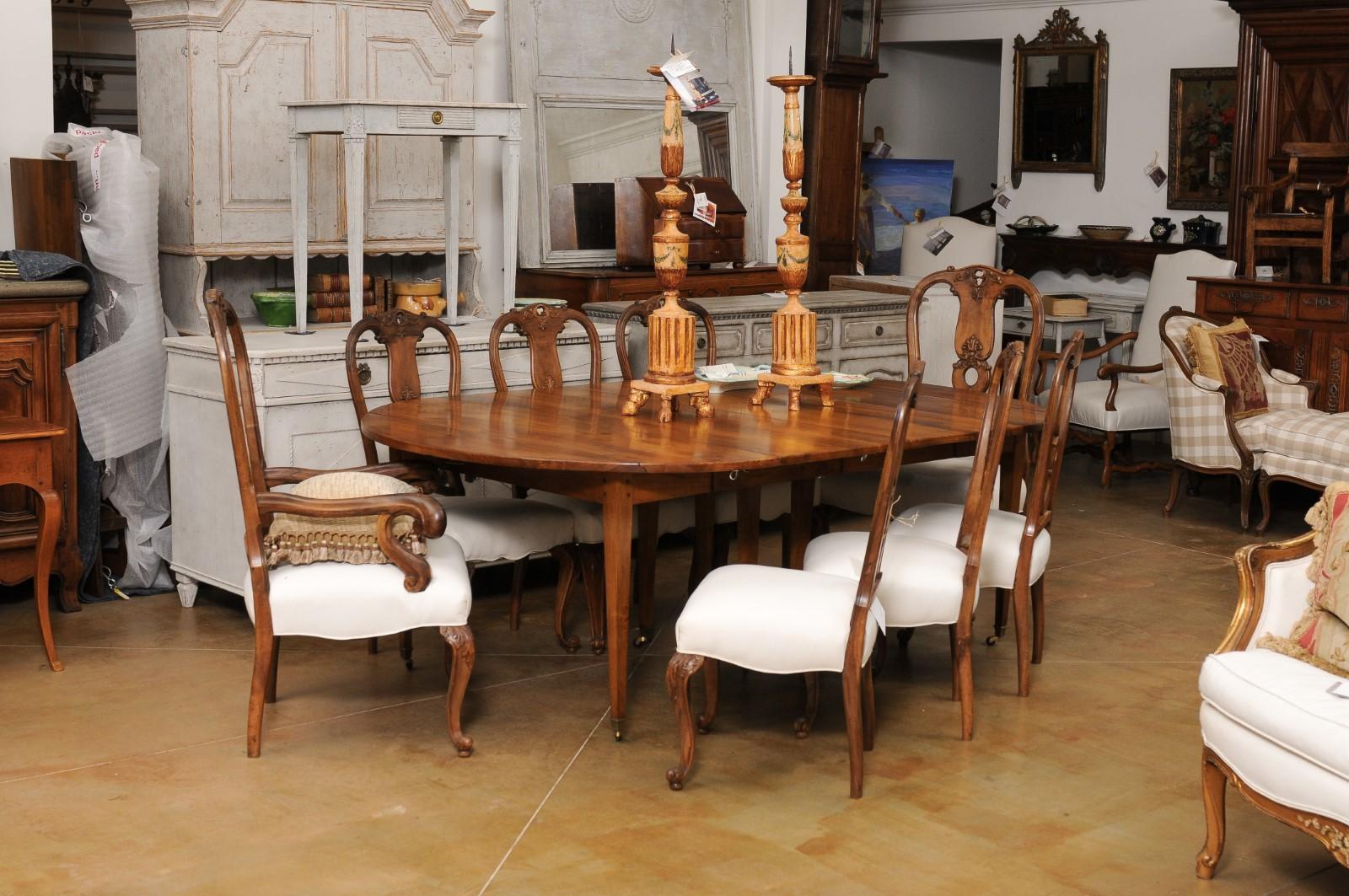 A French walnut oval extension dining room table from the late 19th century, with five leaves, tapered legs and casters. Created in France during the last quarter of the 19th century, this French dining room table features a walnut oval top