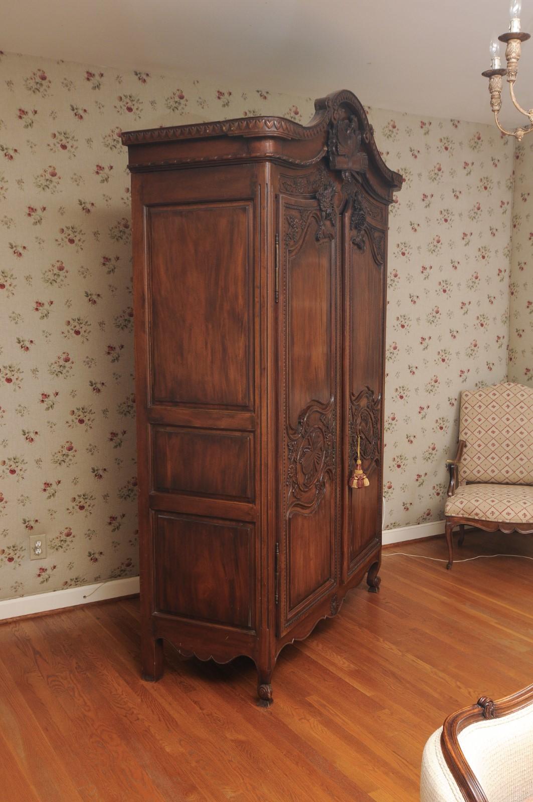 A French walnut wedding armoire from the late 19th century, with carved doves, quiver and musical instruments. Created in France in the last decade of the 19th century, this walnut armoire features a 